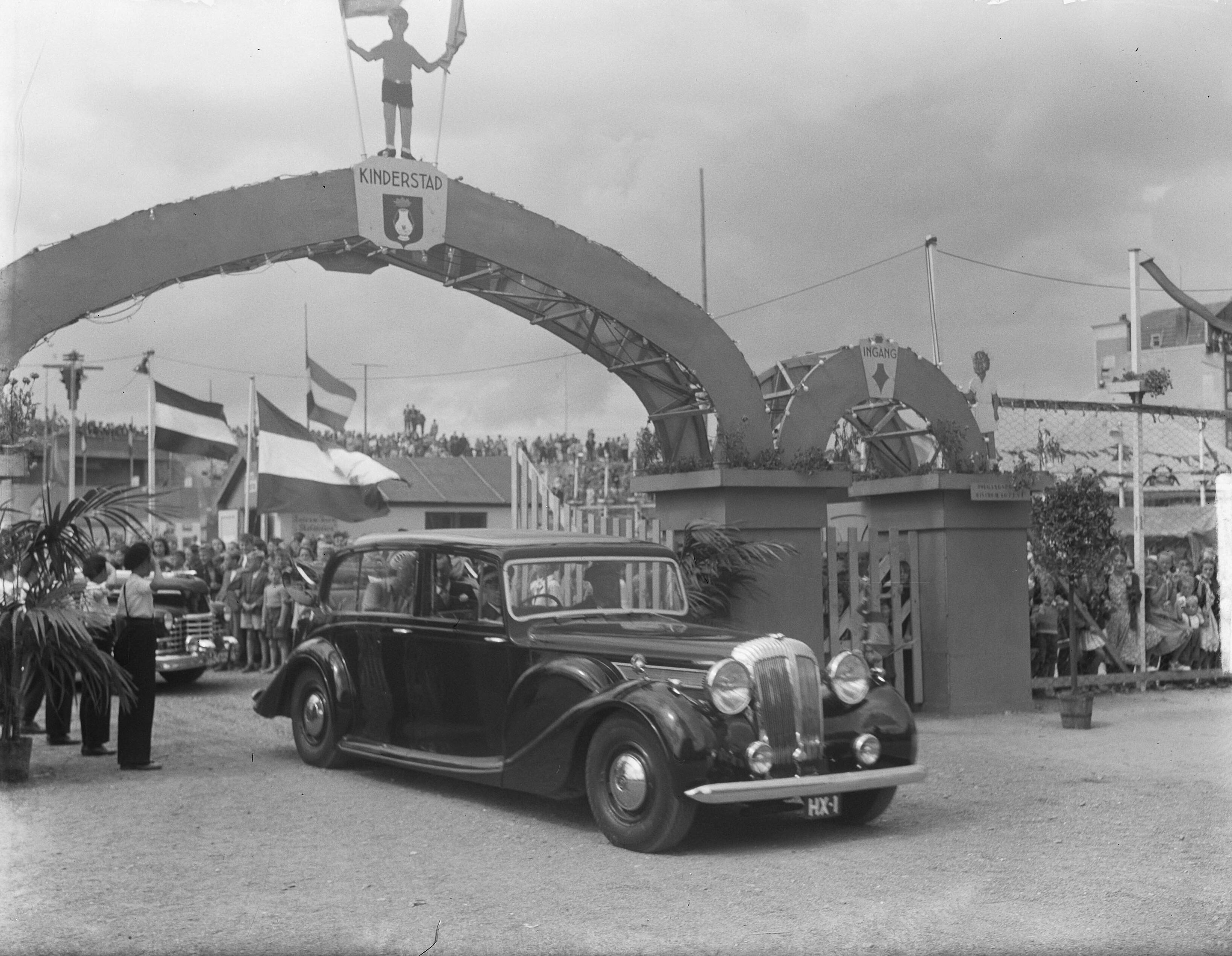 Koninklijk bezoek aan Zeeland (1950) — Koningin Juliana en prins Bernhard verlaten, in een hofauto, "Kinderstad" te Vlissingen — Foto: Pot, Harry / Anefo. Licentie: Set B: Rechtenvrij / Publiek Domein. Bron: Nationaal Archief. http://hdl.handle.net/10648/a8ddb49e-d0b4-102d-bcf8-003048976d84