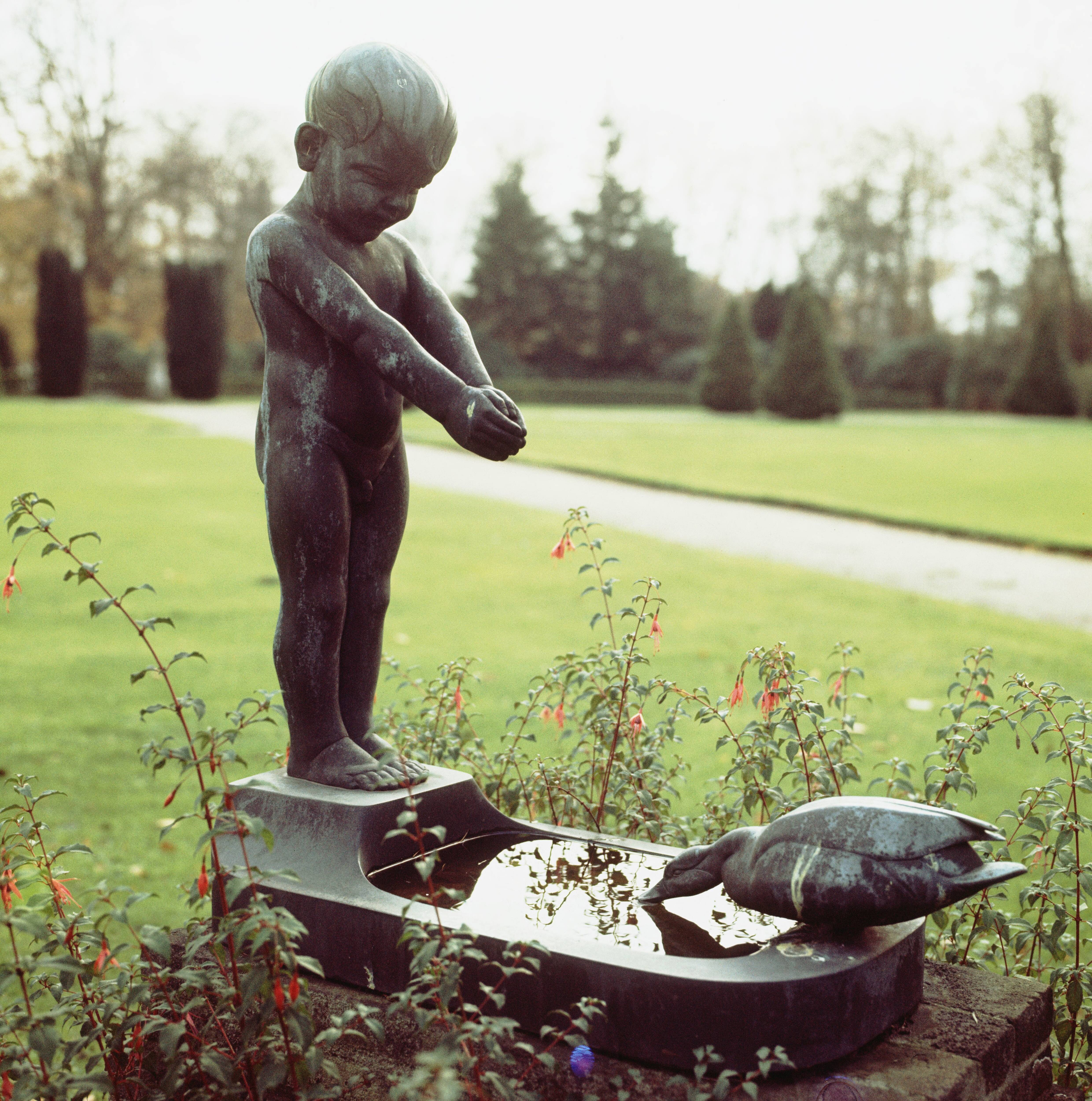 Paleis Soestdijk — Jongetje met eend bij Amalia-tuin — Foto: Onbekend / RVD. Licentie: Set B: Rechtenvrij / Publiek Domein. Bron: Nationaal Archief. http://hdl.handle.net/10648/afa83a38-d0b4-102d-bcf8-003048976d84