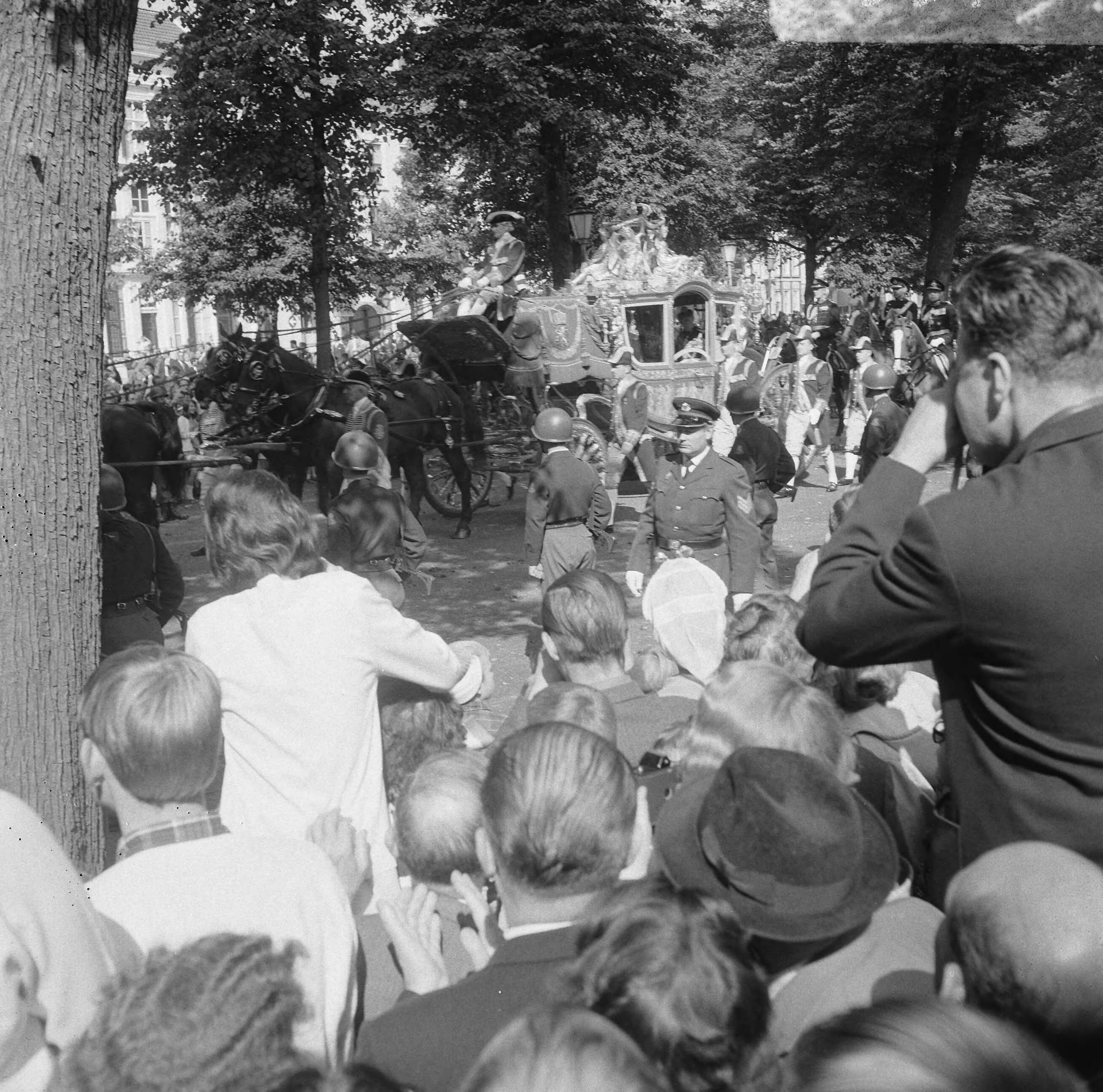 Prinsjesdag 1966 in Den Haag — Mensen zwaaiend naar de Gouden Koets op weg naar de Ridderzaal — Foto: Kroon, Ron / Anefo. Licentie: Set B: Rechtenvrij / Publiek Domein. Bron: Nationaal Archief. http://hdl.handle.net/10648/aafd2016-d0b4-102d-bcf8-003048976d84