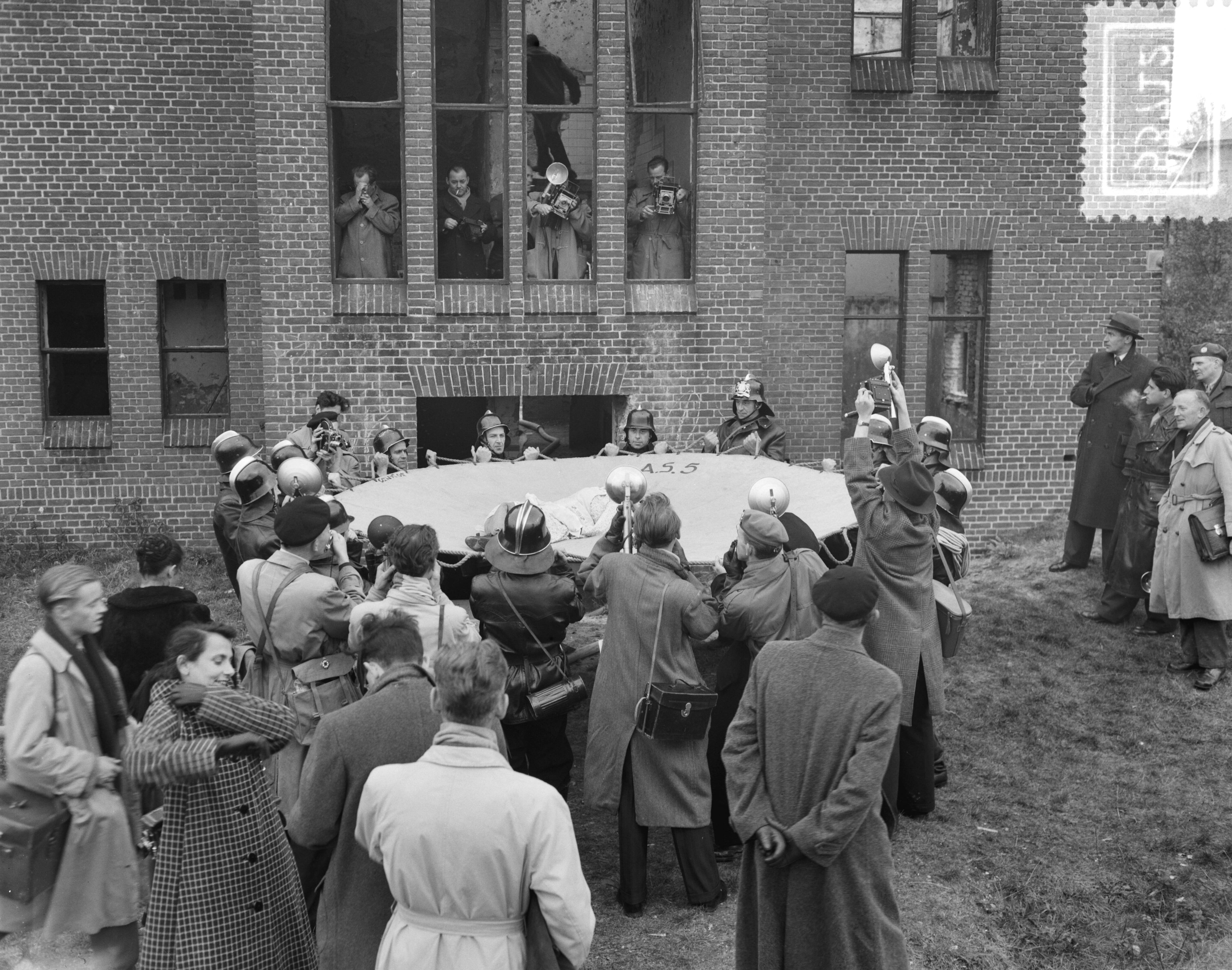 Fotocollectie Anefo — Examen persfotografen te Den Haag. Een brandweeroefening — Foto: Consenheim, Wim / Anefo. Licentie: Set B: Rechtenvrij / Publiek Domein. Bron: Nationaal Archief. http://hdl.handle.net/10648/a9016eac-d0b4-102d-bcf8-003048976d84