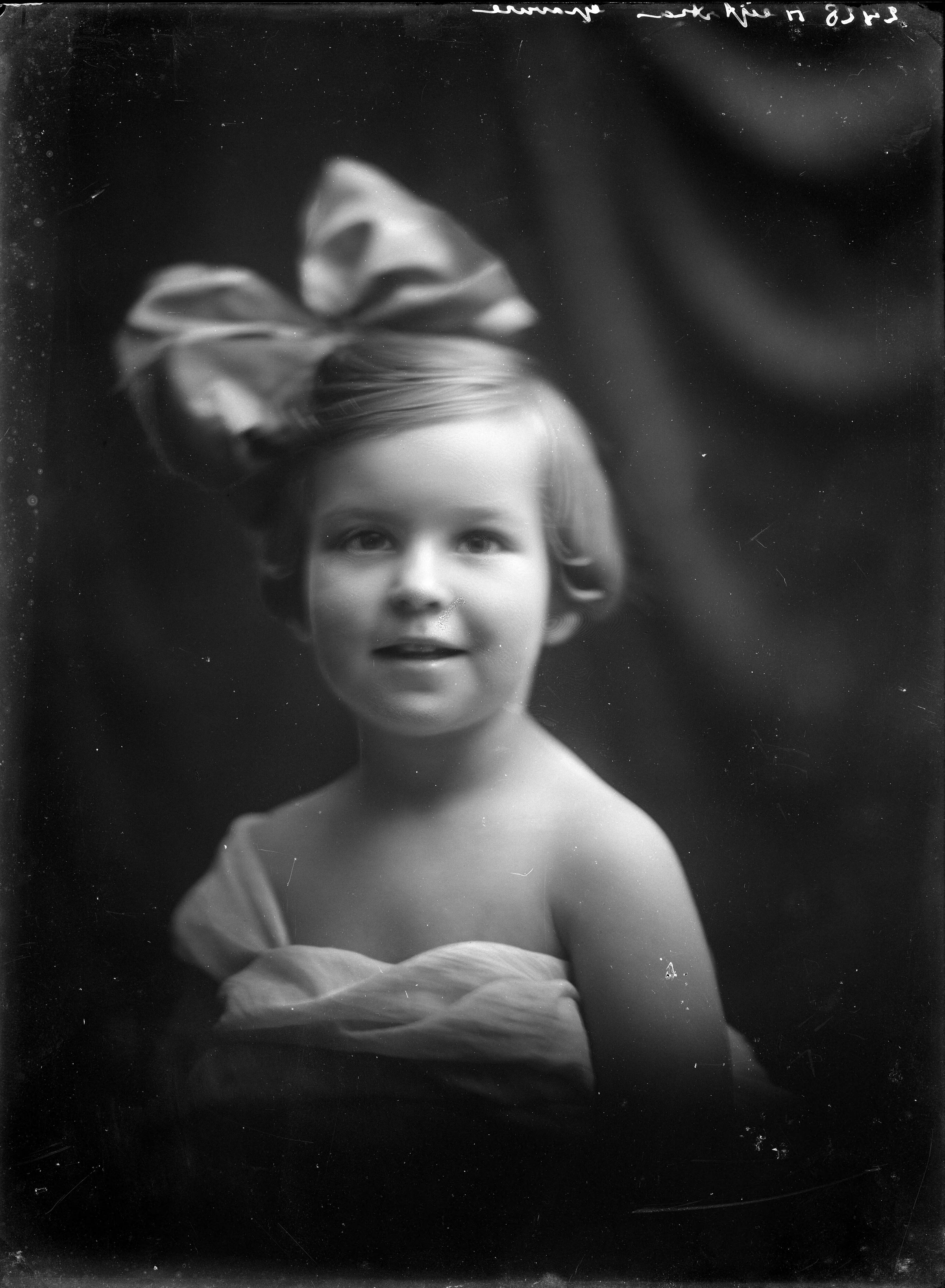 Portretten — Studio-opnames. Portret van een klein meisje met blote schouders en een hele grote strik in het haar. Haarlem, Nederland. 1918-1930. 2428 Heijstra gravure — Foto: Berg, Th.C.J. van den / Spaarnestad Photo (05887). Licentie: Set B: Rechtenvrij / Publiek Domein. Bron: Nationaal Archief. http://hdl.handle.net/10648/35429da7-c623-a382-e063-6df0900a6686