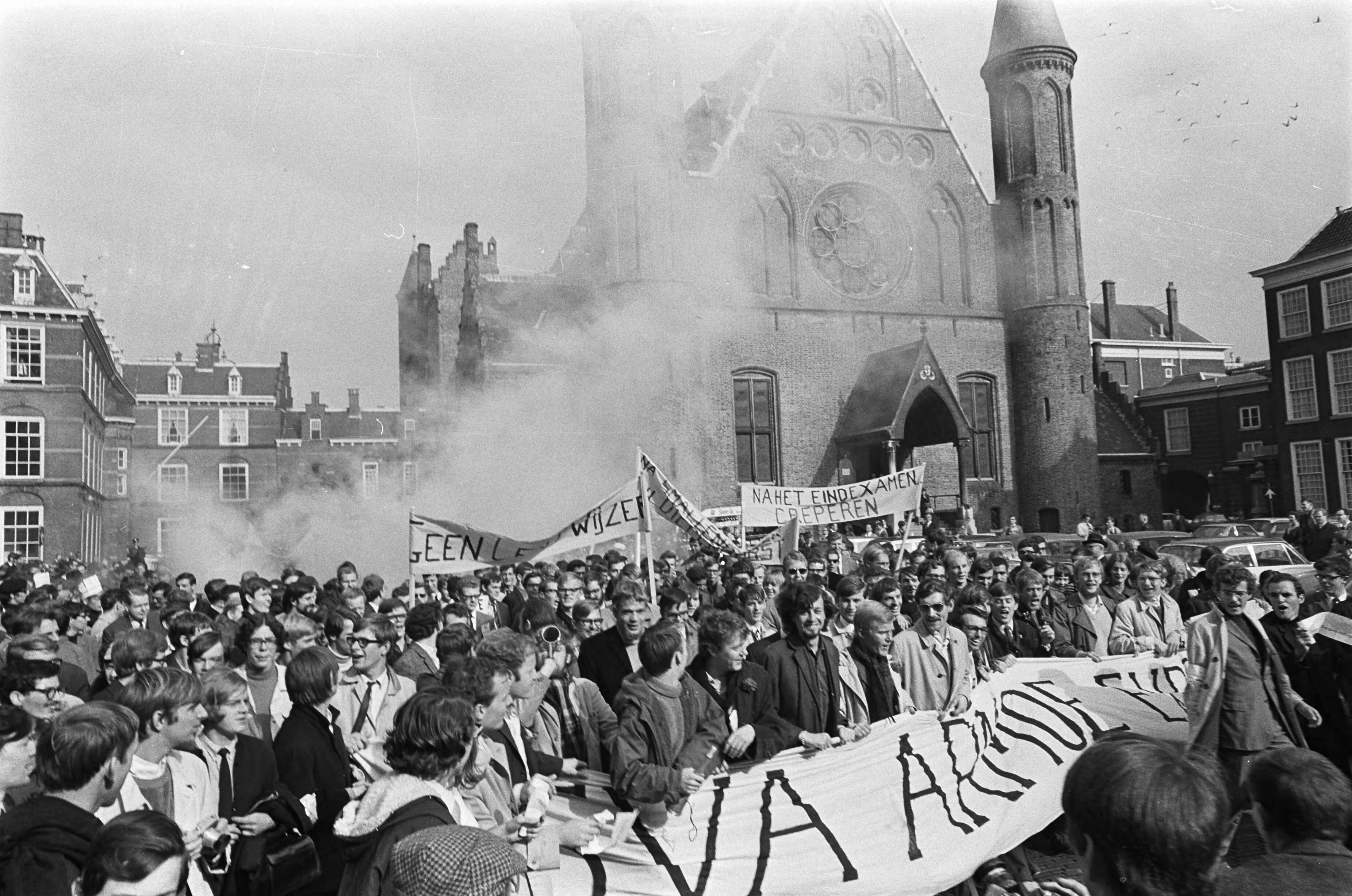 Studentendemonstratie inzake studietoelage, optocht van Amsterdam naar Den Haag — Studenten arriveren met spandoeken en rookbommen op het Haagse Binnenhof — Foto: Fotograaf Onbekend / Anefo. Licentie: Set B: Rechtenvrij / Publiek Domein. Bron: Nationaal Archief. http://hdl.handle.net/10648/aafe5e22-d0b4-102d-bcf8-003048976d84