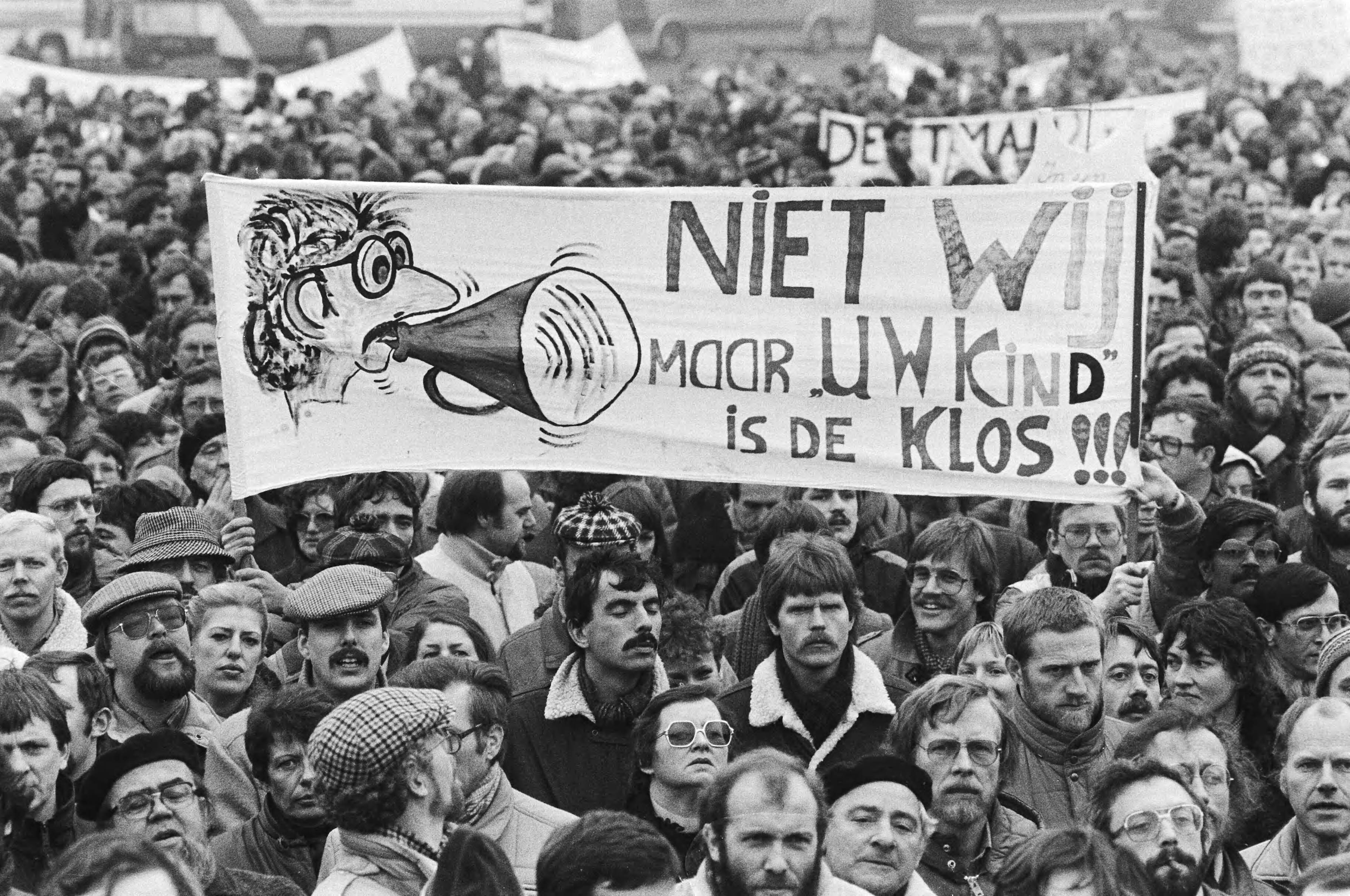 Onderwijsstaking in Den Haag — Manifestatie op het Malieveld, met spandoek "Niet wij maar uw kind is de klos" — Foto: Antonisse, Marcel / Anefo. Licentie: Set B: Rechtenvrij / Publiek Domein. Bron: Nationaal Archief. http://hdl.handle.net/10648/ad232660-d0b4-102d-bcf8-003048976d84