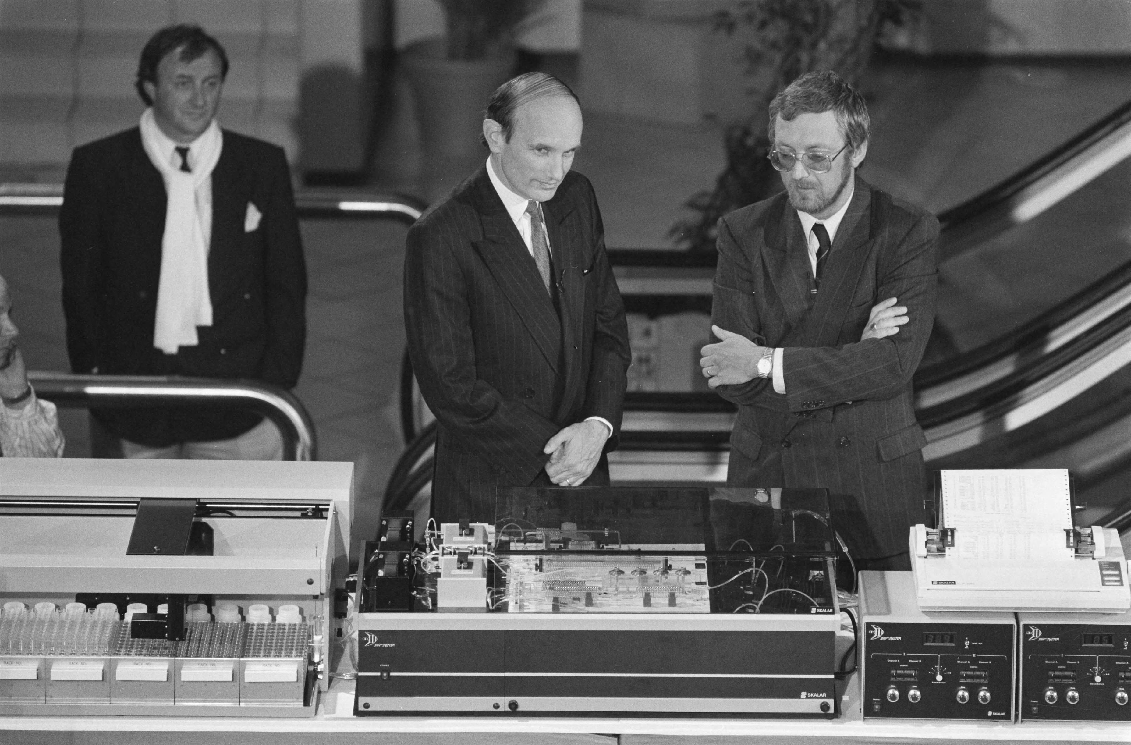 Fotocollectie Anefo — Commissaris van de Koningin Houben bij een stand van het Bredase bedrijf Analitico bij TV-opnamen voor Tros Aktua Export — Foto: Bogaerts, Rob / Anefo. Licentie: Set B: Rechtenvrij / Publiek Domein. Bron: Nationaal Archief. http://hdl.handle.net/10648/ad72c2ec-d0b4-102d-bcf8-003048976d84