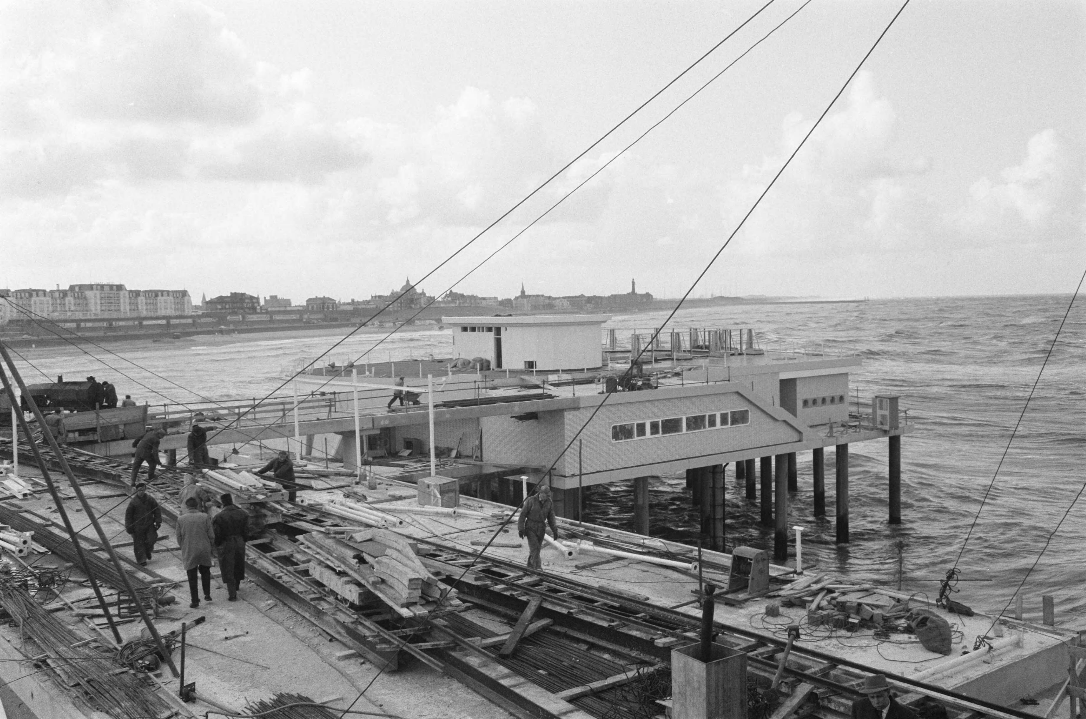 Fotocollectie Anefo — Bouw van de Pier te Scheveningen. Overzicht van de wandelpier met links het restaurant — Foto: Pot, Harry / Anefo. Licentie: Set B: Rechtenvrij / Publiek Domein. Bron: Nationaal Archief. http://hdl.handle.net/10648/a9cedf0e-d0b4-102d-bcf8-003048976d84