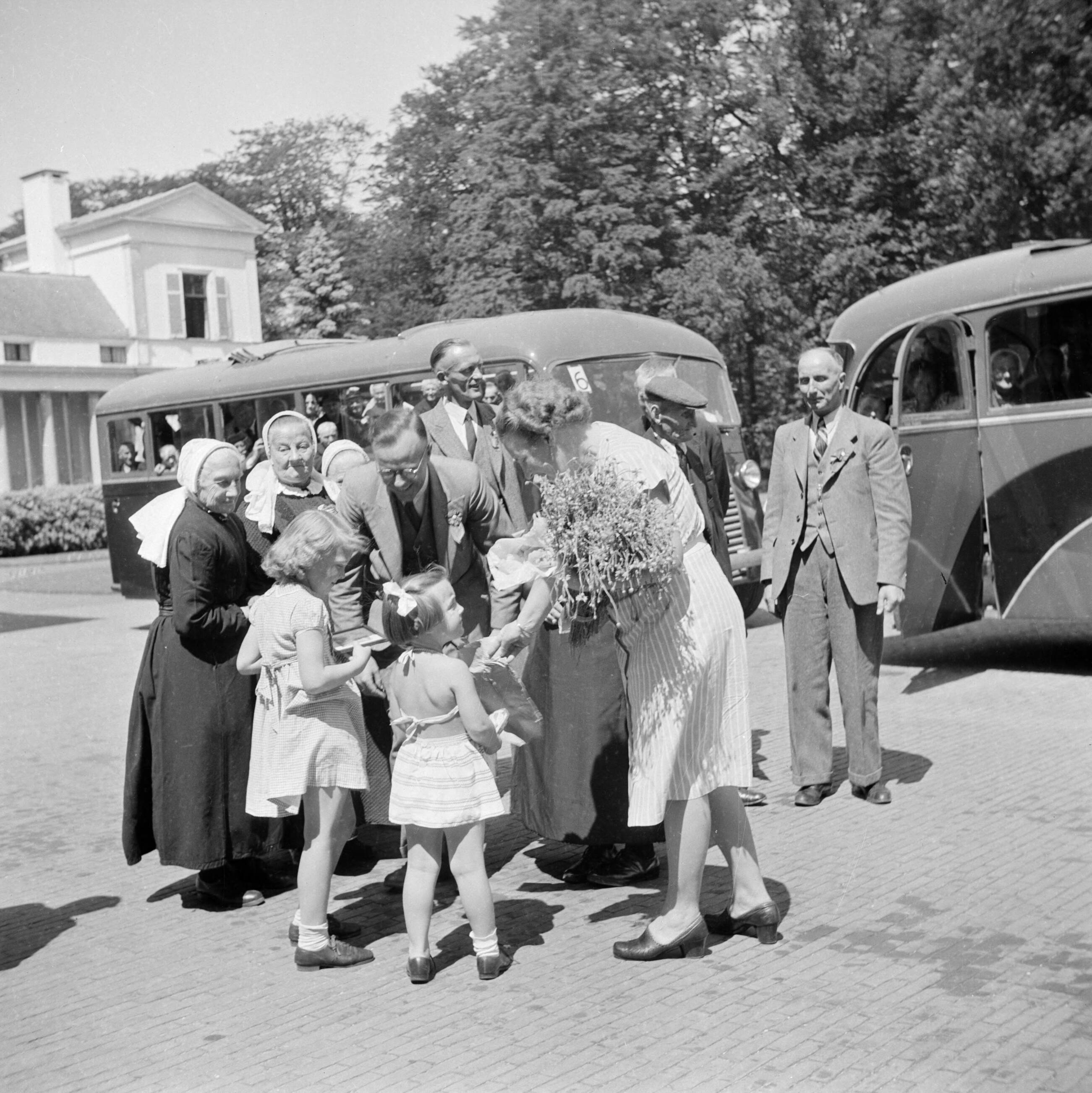 De koninklijke familie op paleis Soestdijk — Prinses Juliana ontvangt een groep mensen in streekdracht vóór het paleis — Foto: Poll, Willem van de. Licentie: Set B: Rechtenvrij / Publiek Domein. Bron: Nationaal Archief. http://hdl.handle.net/10648/aee94542-d0b4-102d-bcf8-003048976d84