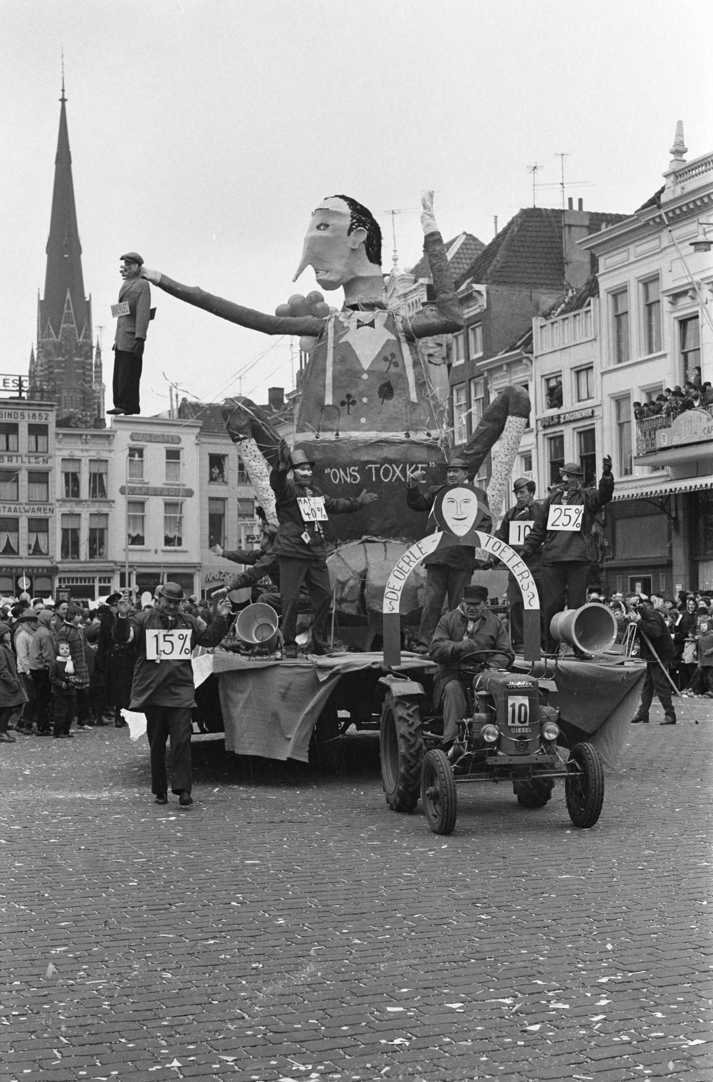 Fotocollectie Anefo — Carnaval in Breda. Praalwagen met pop voorstellende minister Toxopeus met in zijn hand een ambtenaar — Foto: Rossem, Wim van / Anefo. Licentie: Set B: Rechtenvrij / Publiek Domein. Bron: Nationaal Archief. http://hdl.handle.net/10648/a9fbfd72-d0b4-102d-bcf8-003048976d84