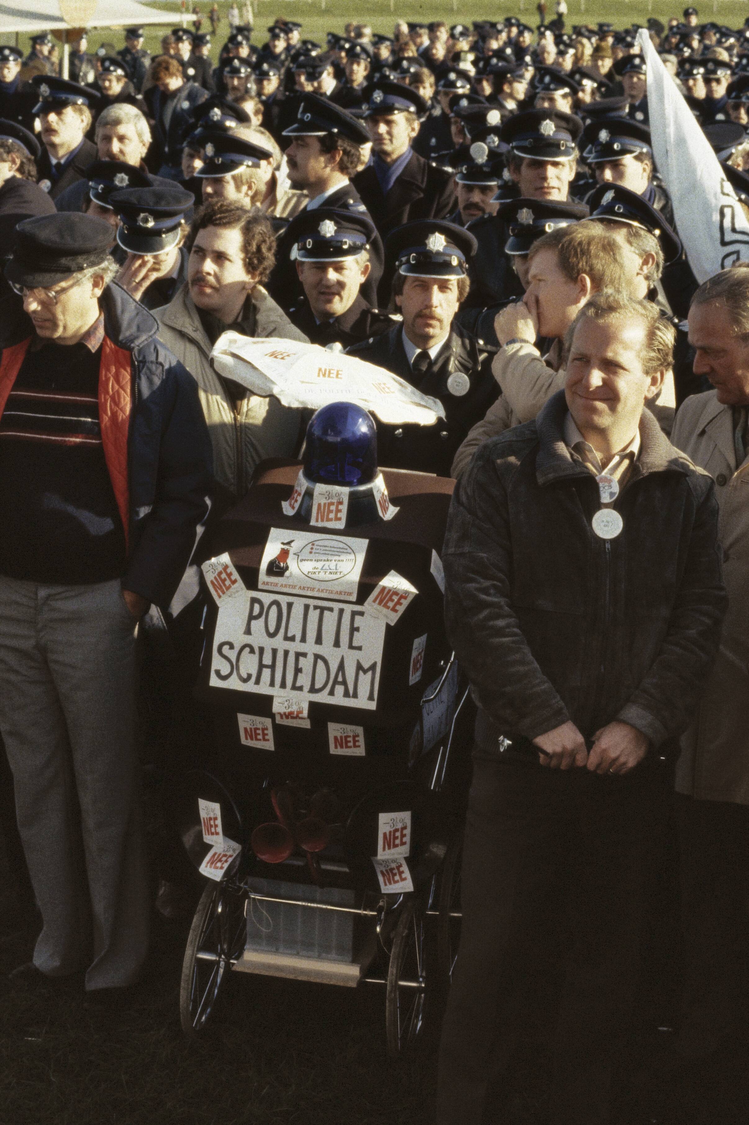 Fotocollectie Anefo — Protest (demonstratie) politiemensen in Den Haag tegen 3,5% korting; demonstranten met kinderwagen met blauw zwaailicht — Foto: Croes, Rob C. / Anefo. Licentie: Set B: Rechtenvrij / Publiek Domein. Bron: Nationaal Archief. http://hdl.handle.net/10648/ad8b6f68-d0b4-102d-bcf8-003048976d84