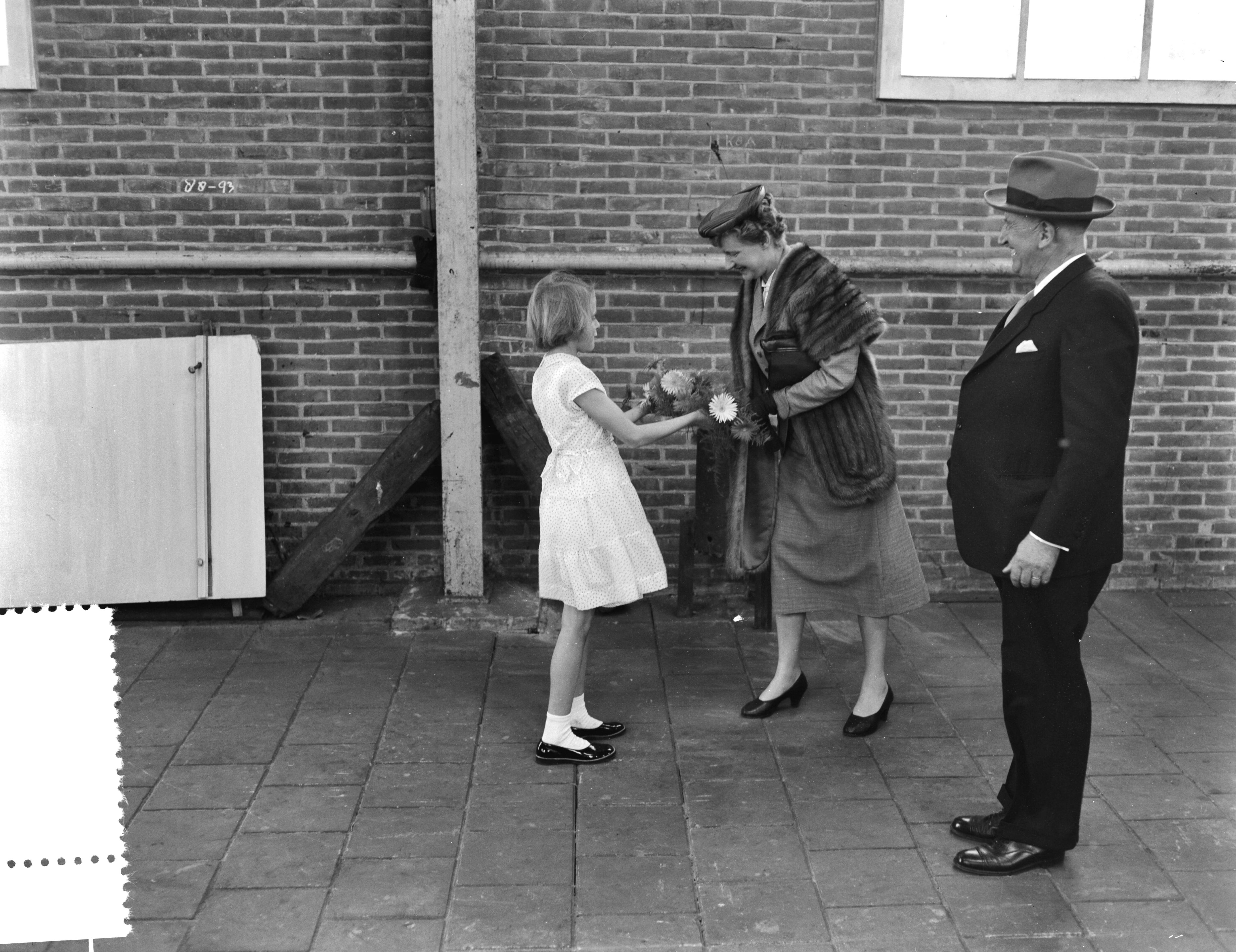 Fotocollectie Anefo — Tewaterlating van de mijnenveger Hr. Ms. "Lisse" bij scheepswerf E.J. Smit & Zn. te Westerbroek. De doopplechtigheid werd verricht door de echtgenote van de burgemeester van Lisse, mevr. W.H.M. de Graaf-Theuling. Zij ontvangt bij aankomst een boeket — Foto: Rossem, Wim van / Anefo. Licentie: Set B: Rechtenvrij / Publiek Domein. Bron: Nationaal Archief. http://hdl.handle.net/10648/a94831ac-d0b4-102d-bcf8-003048976d84