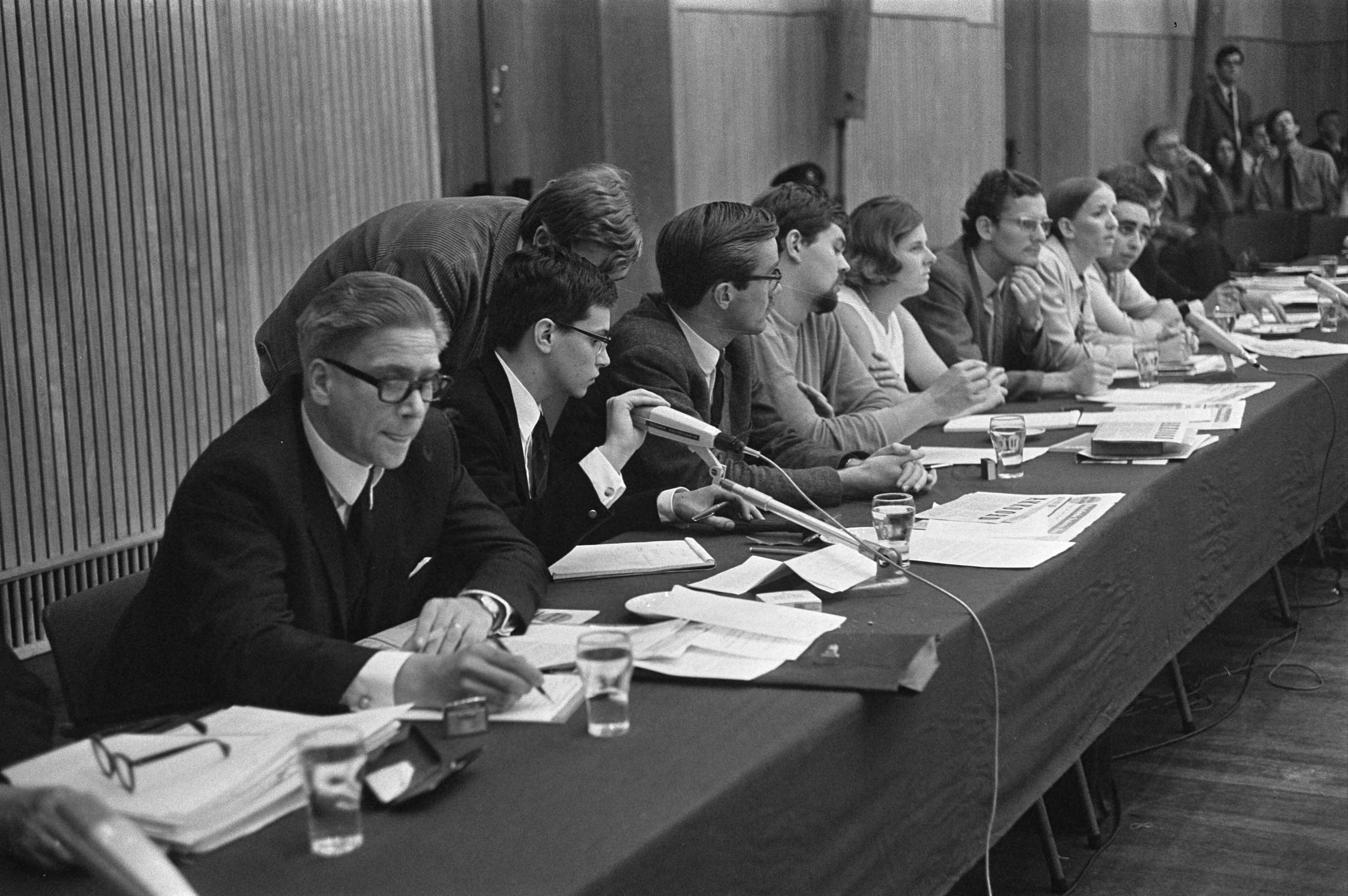 Minister Veringa debatteert met studenten in Leiden — Naast de Minister (links) zit de heer J.K. Wiebenga (voorzitter Raad van Vijftig) — Foto: Fotograaf Onbekend / Anefo. Licentie: Set B: Rechtenvrij / Publiek Domein. Bron: Nationaal Archief. http://hdl.handle.net/10648/ab4d57d4-d0b4-102d-bcf8-003048976d84