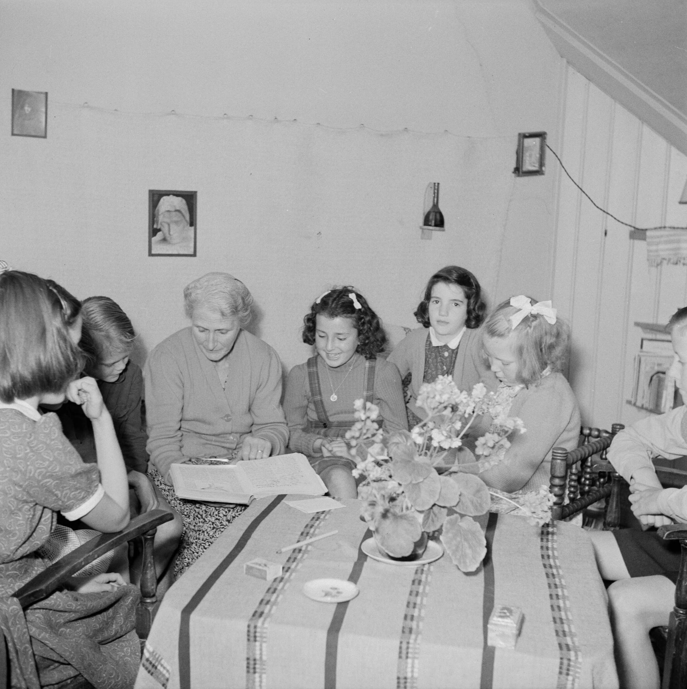 Prinses Beatrix en prinses Irene op de Werkplaats Kindergemeenschap van Kees Boeke te Bilthoven — Prinses Beatrix en klasgenoten worden door Beatrice Boeke-Cadbury voorgelezen — Foto: Poll, Willem van de. Licentie: Set B: Rechtenvrij / Publiek Domein. Bron: Nationaal Archief. http://hdl.handle.net/10648/aee81f1e-d0b4-102d-bcf8-003048976d84
