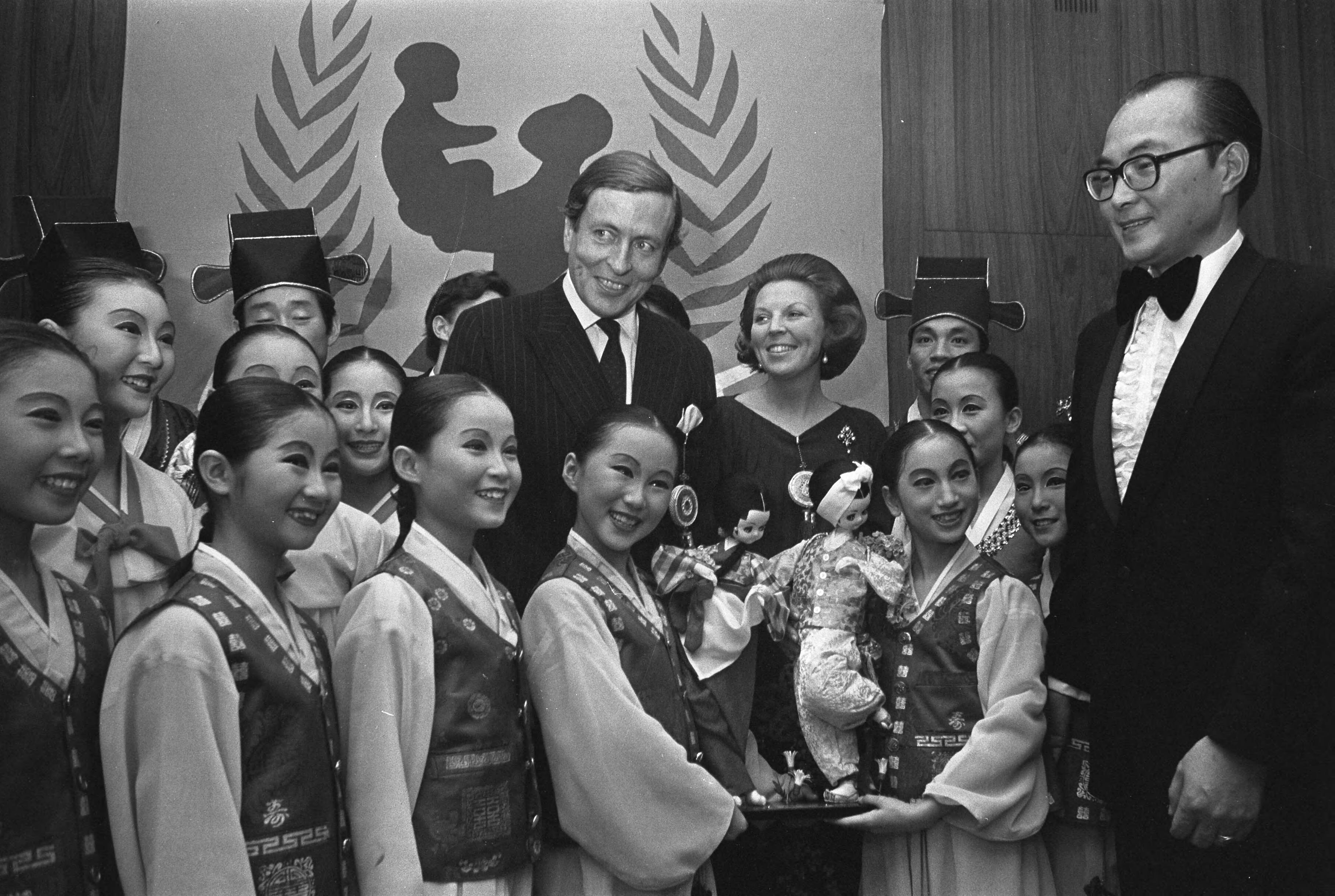 Fotocollectie Anefo — Prinses Beatrix en prins Claus wonen Artiesten helpen Unicef bij in Nederlands Congresgebouw te Den Haag , Beatrix en Claus met The Corea Angels / — Foto: Mieremet, Rob / Anefo. Licentie: Set B: Rechtenvrij / Publiek Domein. Bron: Nationaal Archief. http://hdl.handle.net/10648/ac2015fc-d0b4-102d-bcf8-003048976d84