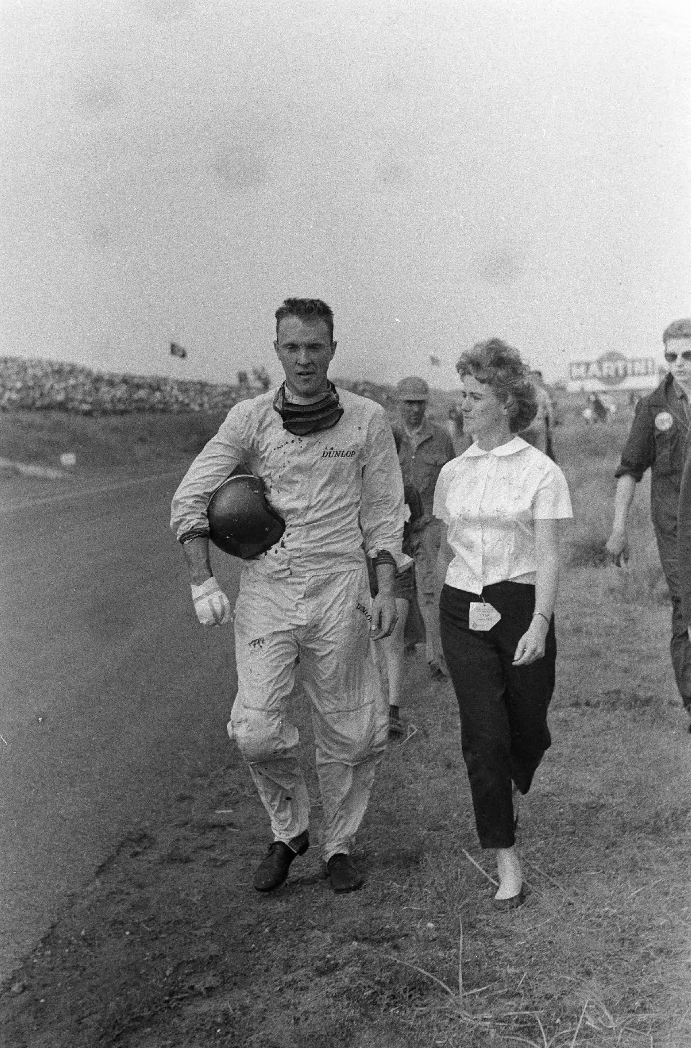 Fotocollectie Anefo — Grote Prijs van Nederland op het circuit van Zandvoort. Dan Gurney wandelt terug naar de pits nadat hij in de Tarzanbocht rechtuit is gereden en over de hekken is gevlogen met zijn BRM F1 wagen door een defect aan de remmen. Hierbij kwam jammerlijk een jonge toeschouwer om het leven. — Foto: Pot, Harry / Anefo. Licentie: Set B: Rechtenvrij / Publiek Domein. Bron: Nationaal Archief. http://hdl.handle.net/10648/a9b1158c-d0b4-102d-bcf8-003048976d84