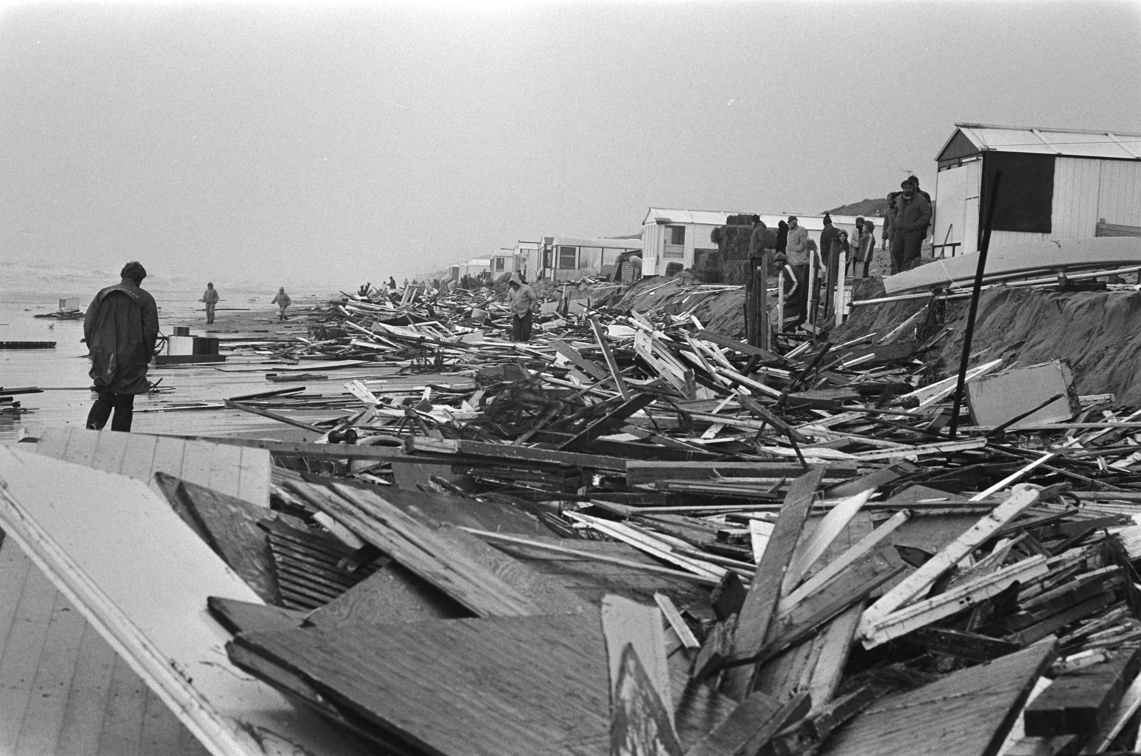 Fotocollectie Anefo — Storm verwoest huisjes langs strand (Zandvoort); mensen brengen bezittingen in veiligheid — Foto: Suyk, Koen / Anefo. Licentie: Set B: Rechtenvrij / Publiek Domein. Bron: Nationaal Archief. http://hdl.handle.net/10648/acde88e8-d0b4-102d-bcf8-003048976d84