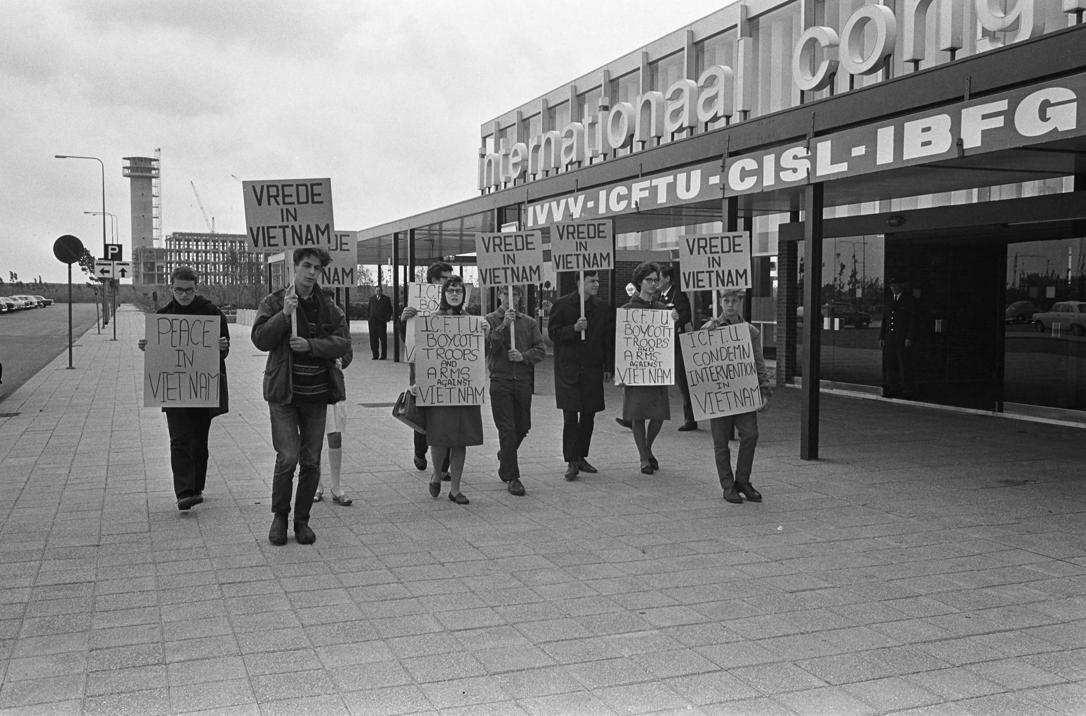 Fotocollectie Anefo — Wereldcongres Vakbeweging in de RAI te Amsterdam, voor de ingang werd gedemonstreerd tegen de oorlog in Vietnam — Foto: Koch, Eric / Anefo. Licentie: Set B: Rechtenvrij / Publiek Domein. Bron: Nationaal Archief. http://hdl.handle.net/10648/aab2bc10-d0b4-102d-bcf8-003048976d84
