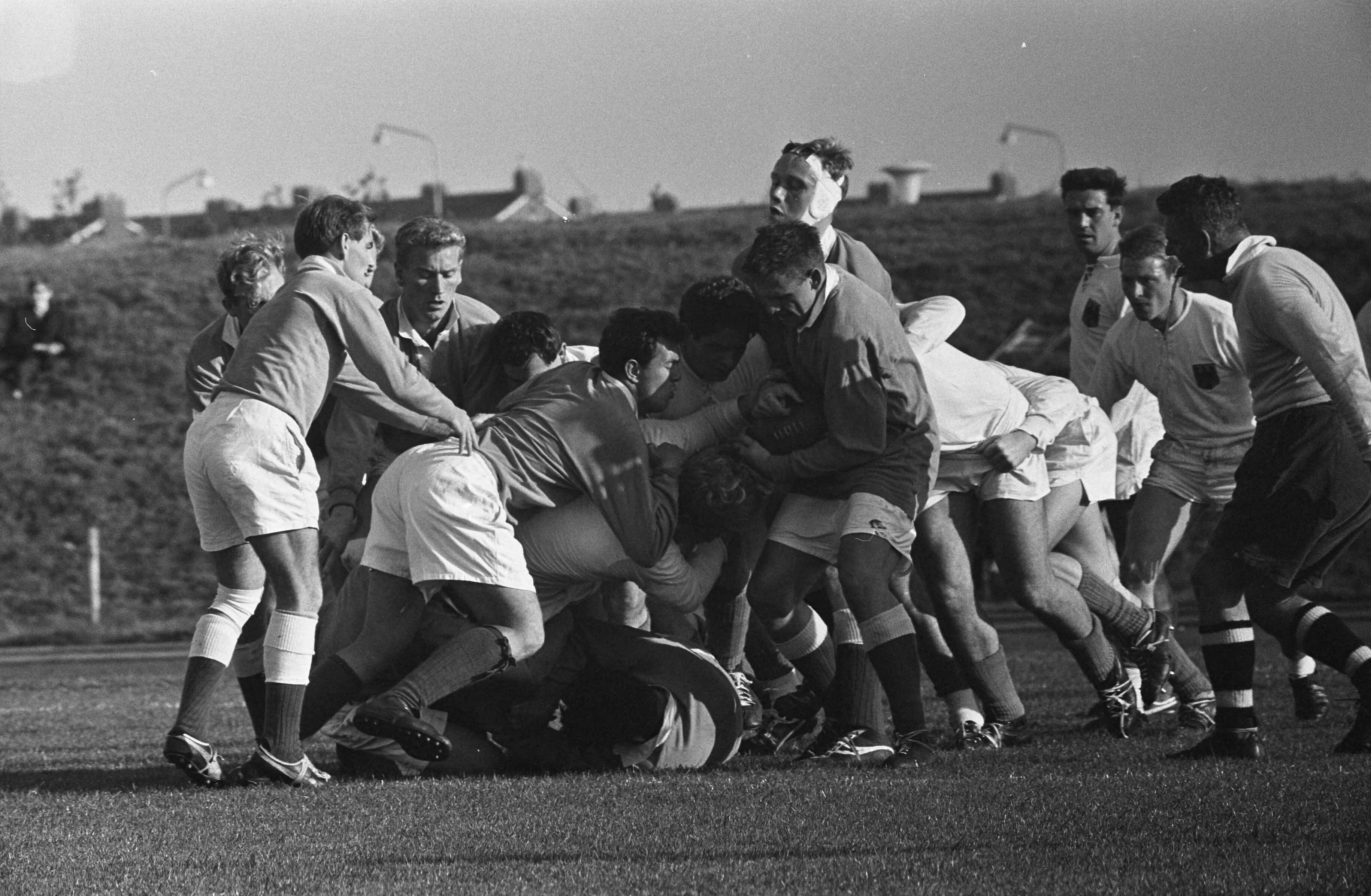 Fotocollectie Anefo — Rugby. Nederland tegen West-Duitsland 6-37. Spelmoment, scrum (Duitsers in het wit) — Foto: Koch, Eric / Anefo. Licentie: Set B: Rechtenvrij / Publiek Domein. Bron: Nationaal Archief. http://hdl.handle.net/10648/aa1c4276-d0b4-102d-bcf8-003048976d84