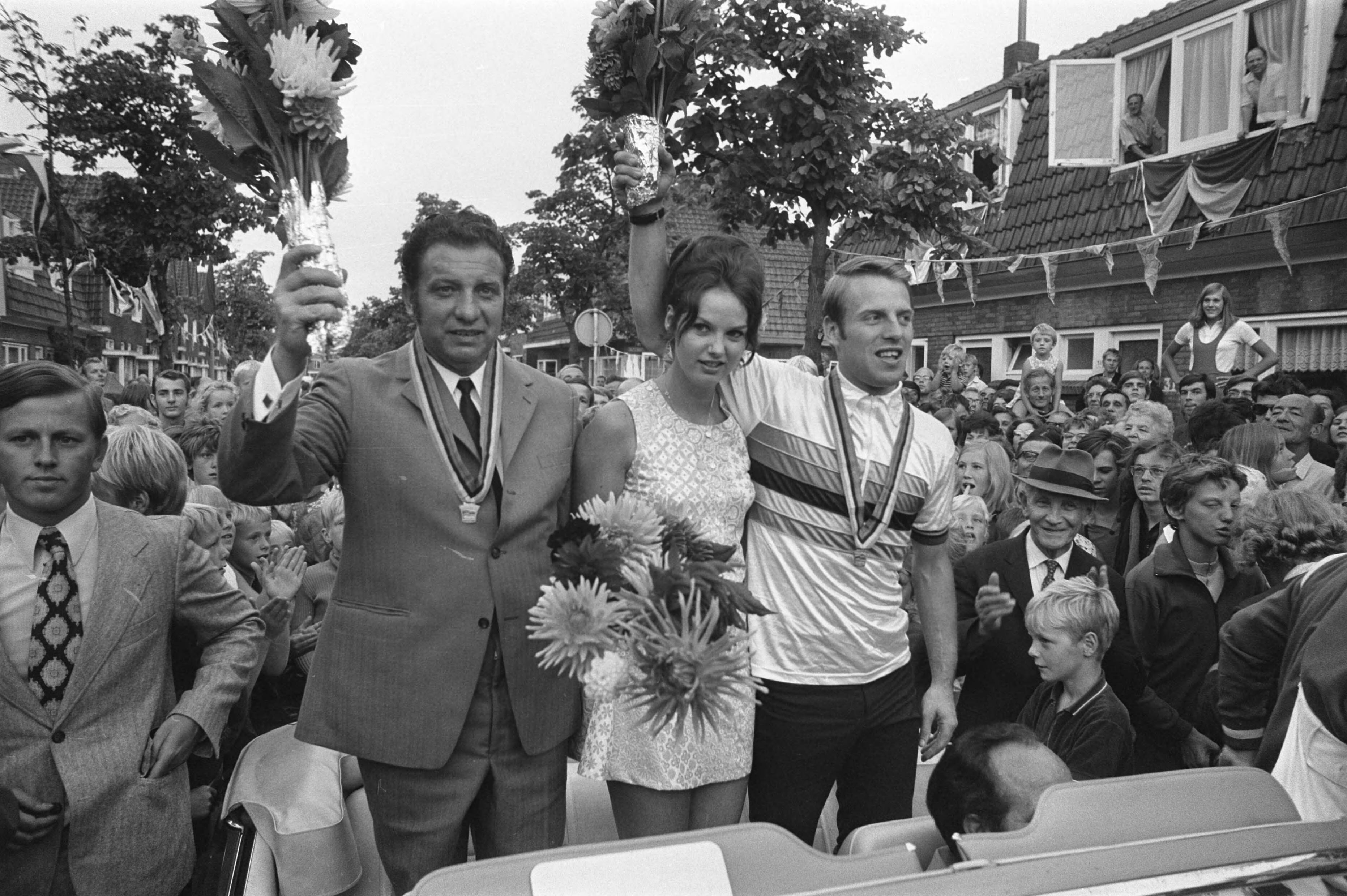 Fotocollectie Anefo — Wielrenner Cees Stam wordt gehuldigd in Koog aan de Zaan ; gangmaker Stakenburg en Stam en echtgenote in auto in het dorp — Foto: Verhoeff, Bert / Anefo. Licentie: Set B: Rechtenvrij / Publiek Domein. Bron: Nationaal Archief. http://hdl.handle.net/10648/ab9f7a14-d0b4-102d-bcf8-003048976d84