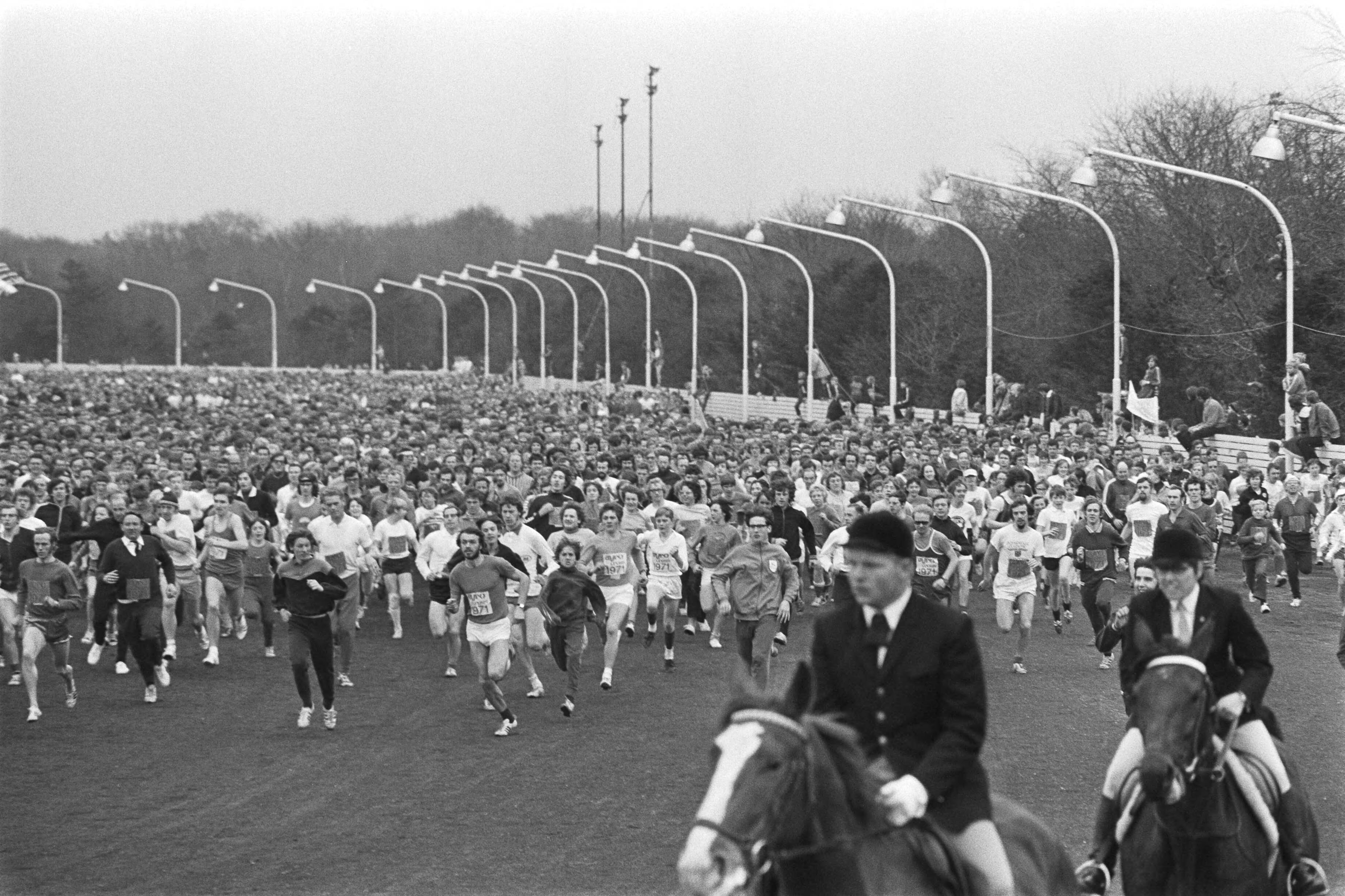 Jaarlijkse AVRO-cross 1971 in Hilversum — Start van de hardloopwedstrijd met ongeveer 6000 deelnemers op de drafbaan van het Sportpark Hilversum, een jockey begeleidt te paard — Foto: Fotograaf Onbekend / Anefo. Licentie: Set B: Rechtenvrij / Publiek Domein. Bron: Nationaal Archief. http://hdl.handle.net/10648/abb72d9e-d0b4-102d-bcf8-003048976d84