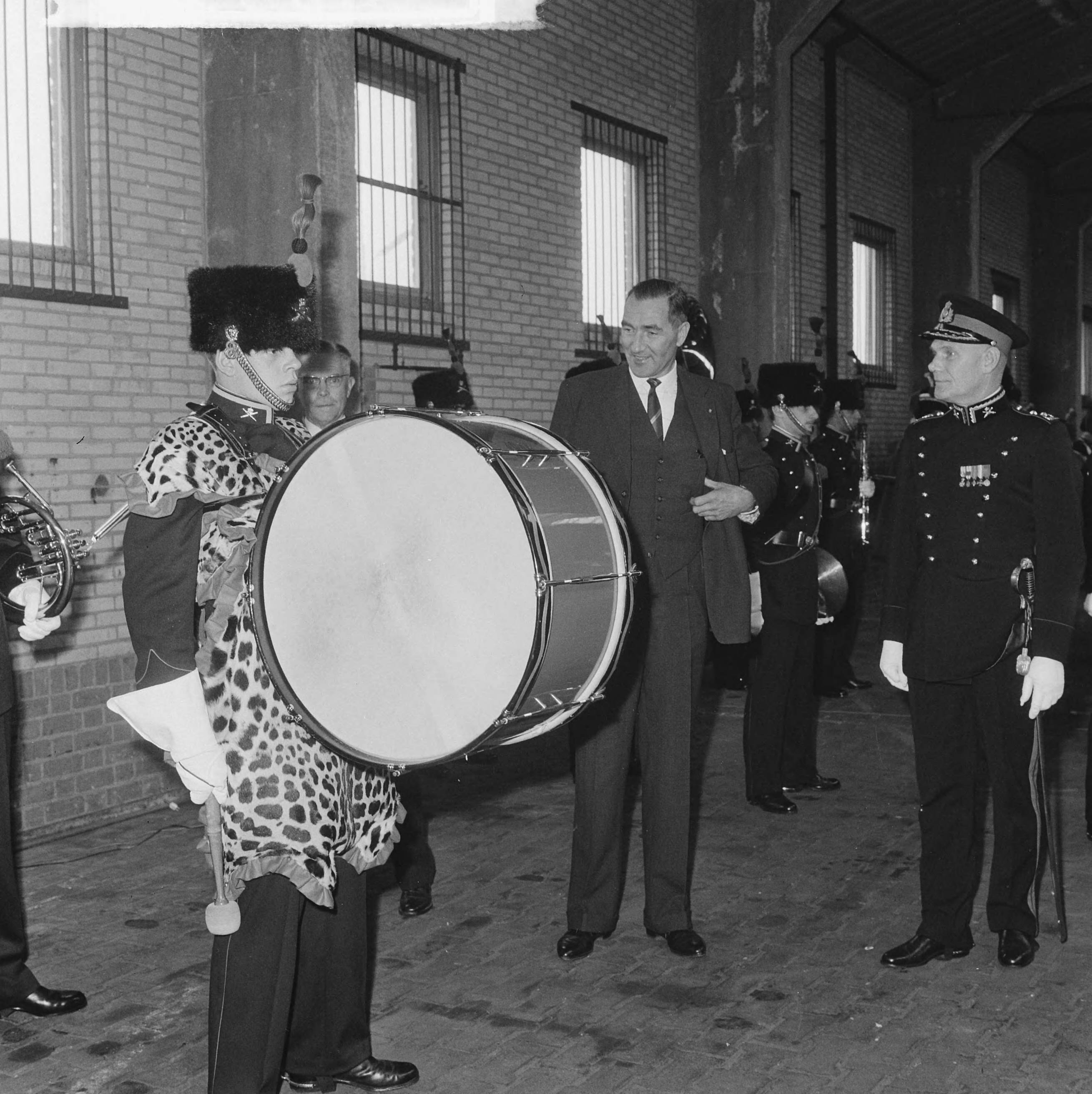 Fotocollectie Anefo — In de Chassé kazerne te Breda is het Artillerie Trompetterkorps officieel geïnstalleerd als fanfarekorps der Artillerie, door staatssecretaris J.C.E. Haex, de staatssecretaris (links) en generaal-majoor B. Andringa bekijken een tromdrager met pantervel — Foto: Koch, Eric / Anefo. Licentie: Set B: Rechtenvrij / Publiek Domein. Bron: Nationaal Archief. http://hdl.handle.net/10648/aa67ac48-d0b4-102d-bcf8-003048976d84