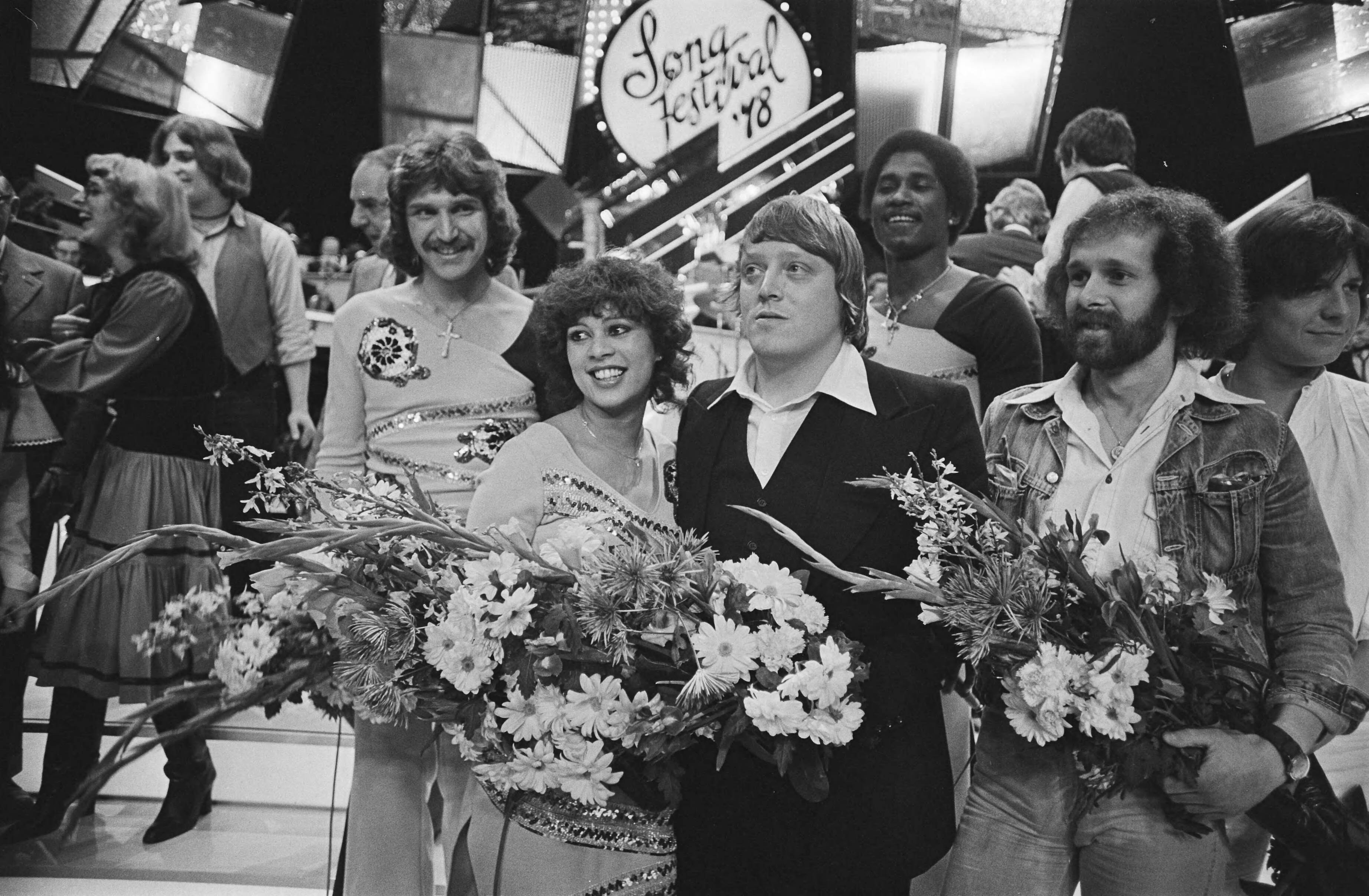 Fotocollectie Anefo — Nationaal Songfestival in Den Haag ; het winnende trio Harmony in de bloemen en tekstschrijver Dik Kooyman (r) en componist Eddy Owens — Foto: Suyk, Koen / Anefo. Licentie: Set B: Rechtenvrij / Publiek Domein. Bron: Nationaal Archief. http://hdl.handle.net/10648/acace8c4-d0b4-102d-bcf8-003048976d84
