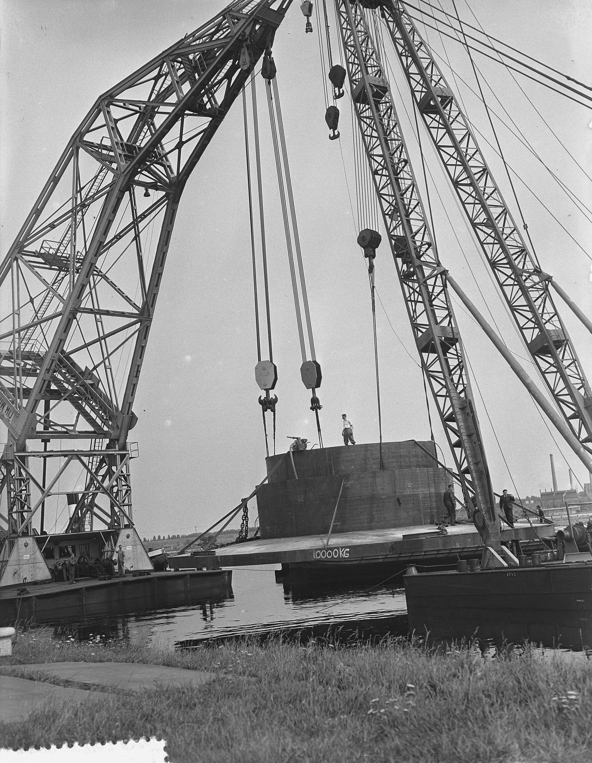 Fotocollectie Anefo — Tewaterlating in Zaandam van de duikerklok bestemd voor een onderzoek naar de veronderstelde lading goud aan boord van het wrak van de "Renate Leonhardt" — Foto: Noske, J.D. / Anefo. Licentie: Set B: Rechtenvrij / Publiek Domein. Bron: Nationaal Archief. http://hdl.handle.net/10648/a9274c9e-d0b4-102d-bcf8-003048976d84