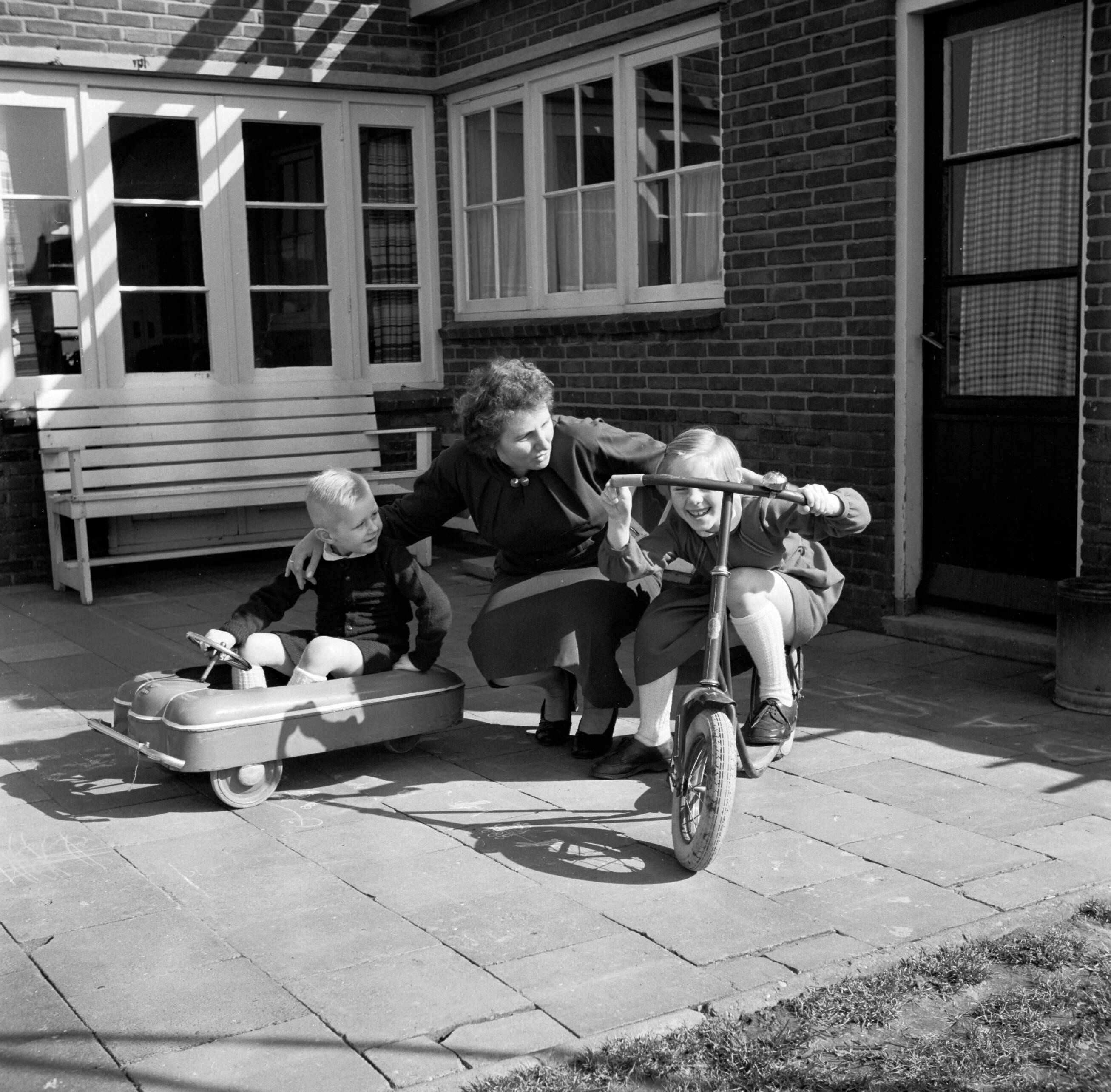 Fotocollectie Van de Poll — De echtgenote van Gerard de Jong met vierjarige zoon Gerrie en achtjarige dochter Marietje op een plaatsje bij hun huis — Foto: Poll, Willem van de. Licentie: Set B: Rechtenvrij / Publiek Domein. Bron: Nationaal Archief. http://hdl.handle.net/10648/aecccc46-d0b4-102d-bcf8-003048976d84