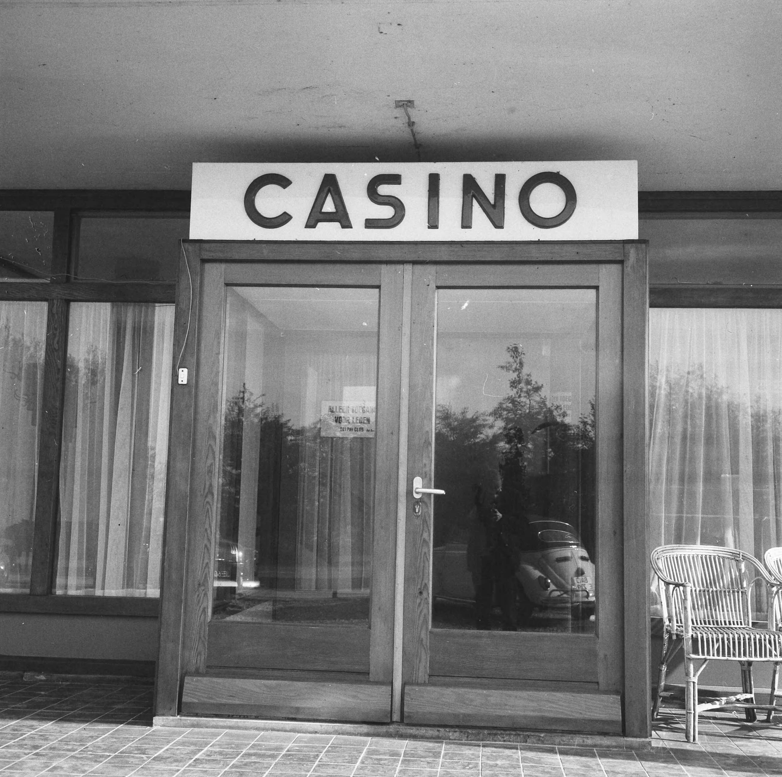 Fotocollectie Anefo — Naar aanleiding van een besluit van het ministerie van Justitie moeten de casino's in Nederland hun deuren sluiten. In West-End te Loosdrecht rolt vandaag voor het laatst het balletje. Entree van het casino — Foto: Evers, Joost / Anefo. Licentie: Set B: Rechtenvrij / Publiek Domein. Bron: Nationaal Archief. http://hdl.handle.net/10648/aac85bf6-d0b4-102d-bcf8-003048976d84