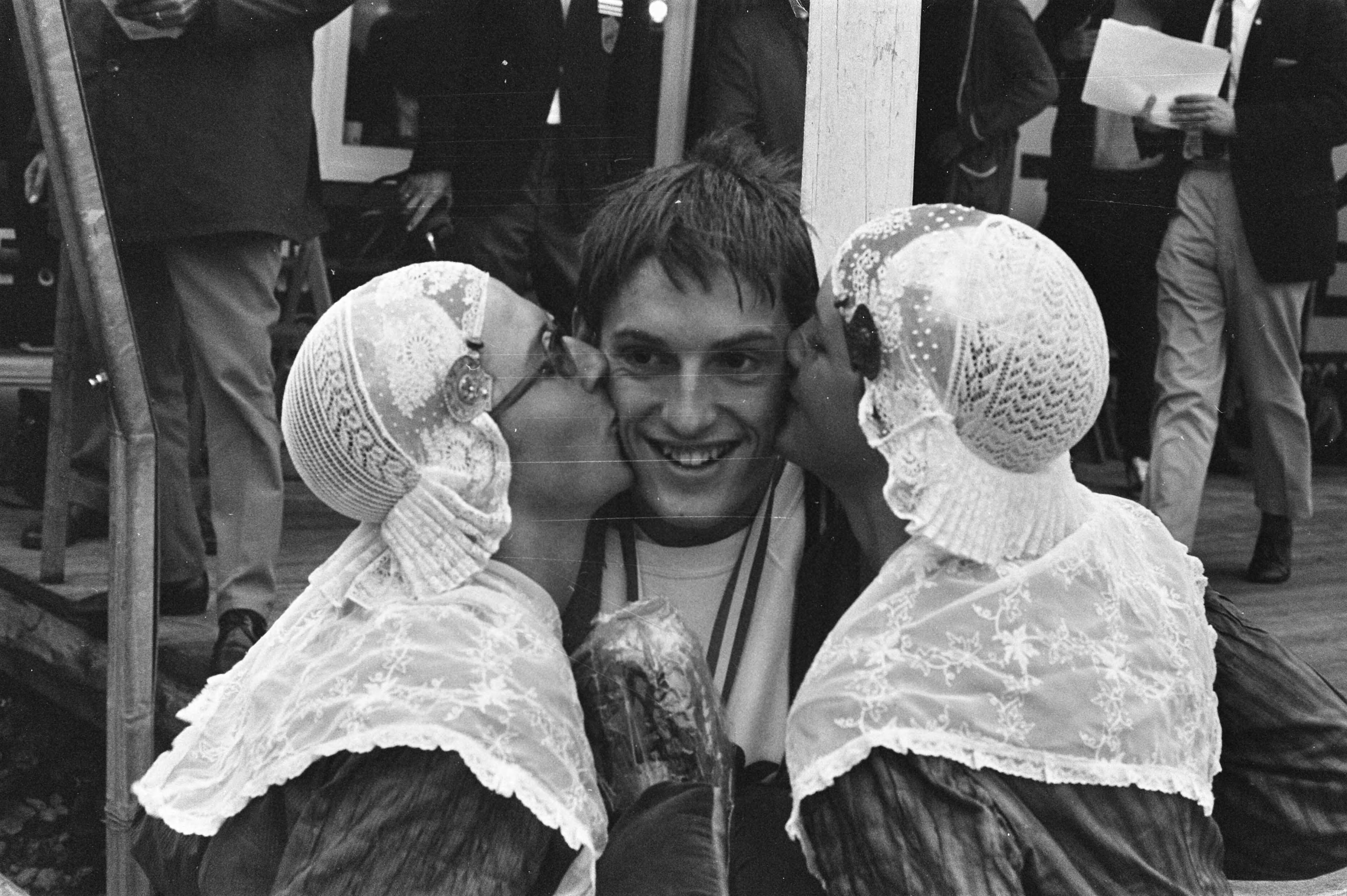 Fotocollectie Anefo — Nationale zwemkampioenschappen in Leeuwarden; Bob Schoutsen wordt gefeliciteerd door vrouwen in klederdracht — Foto: Verhoeff, Bert / Anefo. Licentie: Set B: Rechtenvrij / Publiek Domein. Bron: Nationaal Archief. http://hdl.handle.net/10648/ab9d9942-d0b4-102d-bcf8-003048976d84