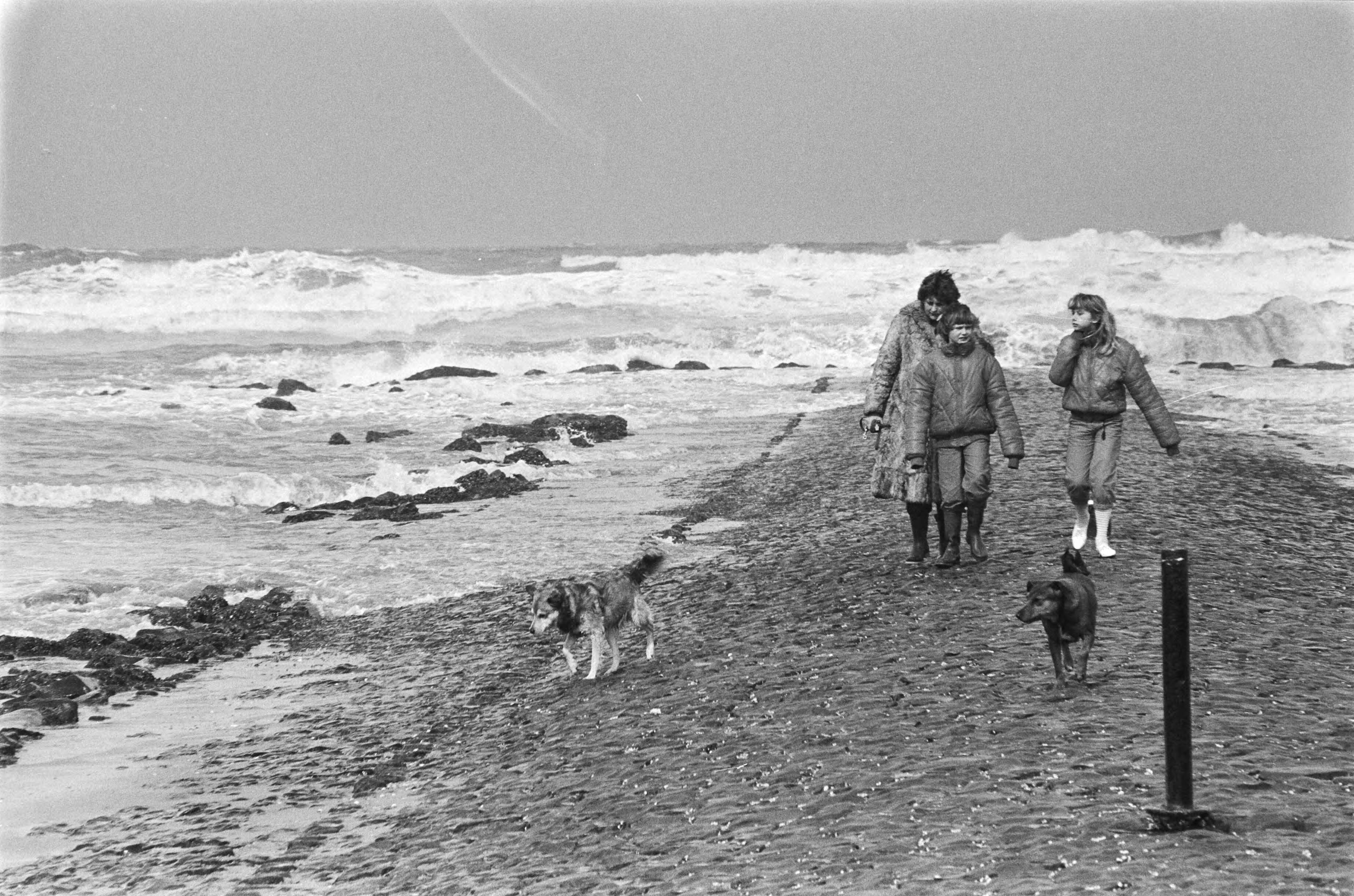 Fotocollectie Anefo — Strandtenten opgeslagen op boulevard van Scheveningen in verband met het slechte weer. Wandelaars op strand tijdens slecht weer — Foto: Dijk, Hans van / Anefo. Licentie: Set B: Rechtenvrij / Publiek Domein. Bron: Nationaal Archief. http://hdl.handle.net/10648/ad15021a-d0b4-102d-bcf8-003048976d84
