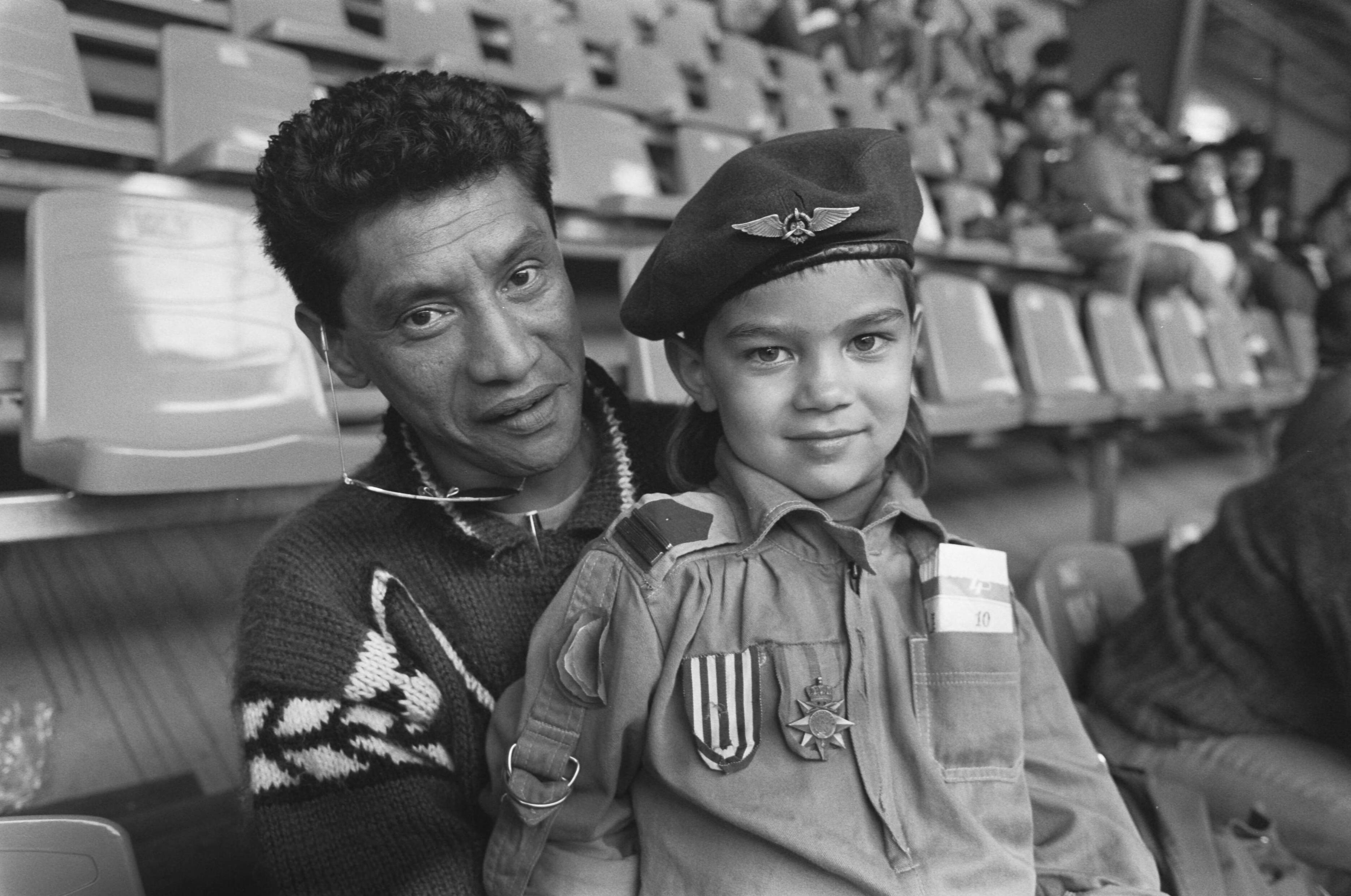Fotocollectie Anefo — Herdenking Republiek der Zuid Molukken in Houtrusthallen in Den Haag ; jonge Zuid Molukker in "militair" pakje brengt groet met zijn vader — Foto: Bogaerts, Rob / Anefo. Licentie: Set B: Rechtenvrij / Publiek Domein. Bron: Nationaal Archief. http://hdl.handle.net/10648/ad6a39c4-d0b4-102d-bcf8-003048976d84