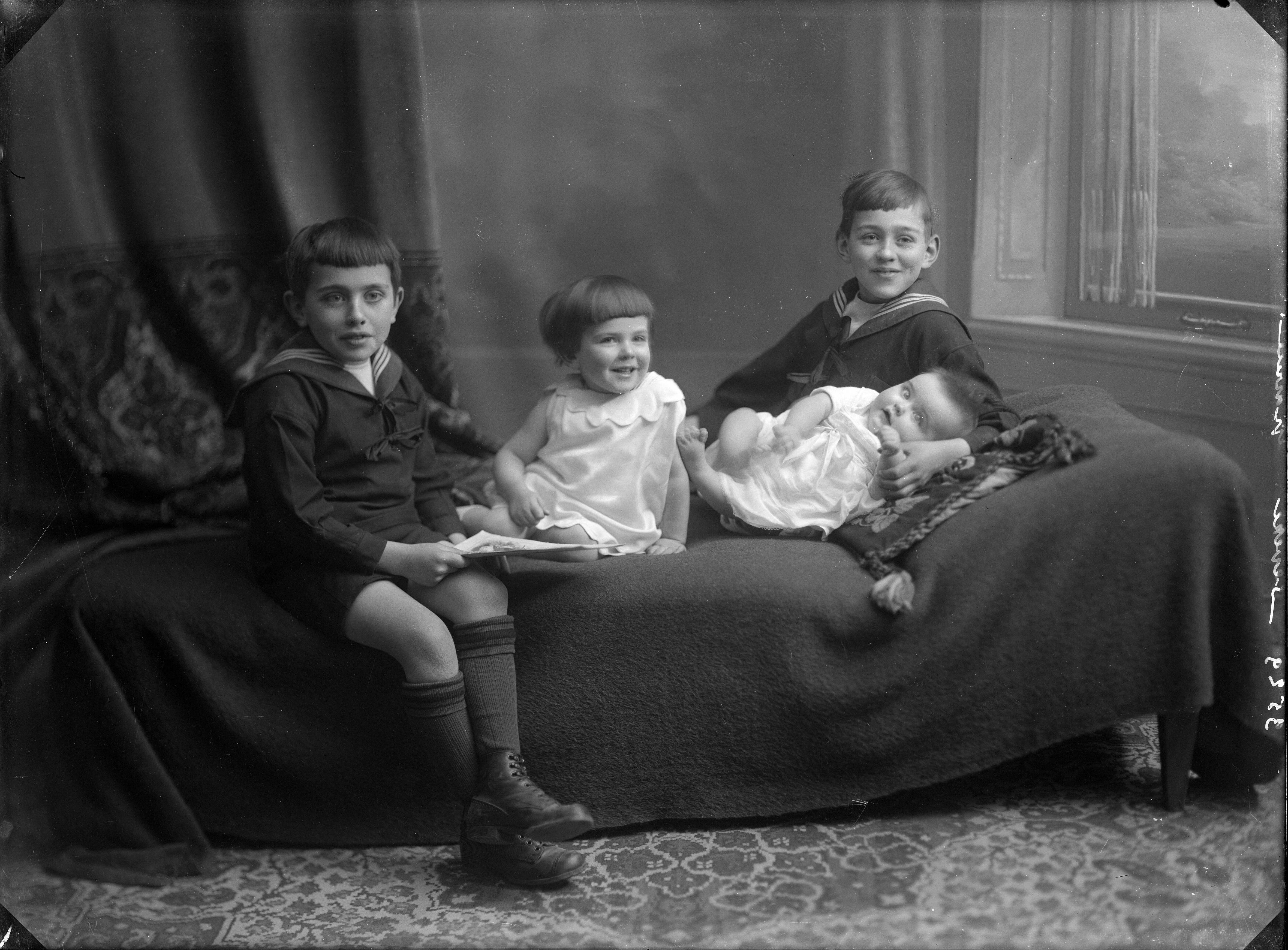 Berg, van den (BERG 050) — Studio-opnames. Twee jongens in matrozenpakjes, een peutermeisje en een baby op een sofa. Haarlem, Nederland. 1918-1930. 3529 Seveke gravure — Foto: Berg, Th.C.J. van den / Spaarnestad Photo (05887). Licentie: Set B: Rechtenvrij / Publiek Domein. Bron: Nationaal Archief. http://hdl.handle.net/10648/35429da7-c7f6-a382-e063-6df0900a6686