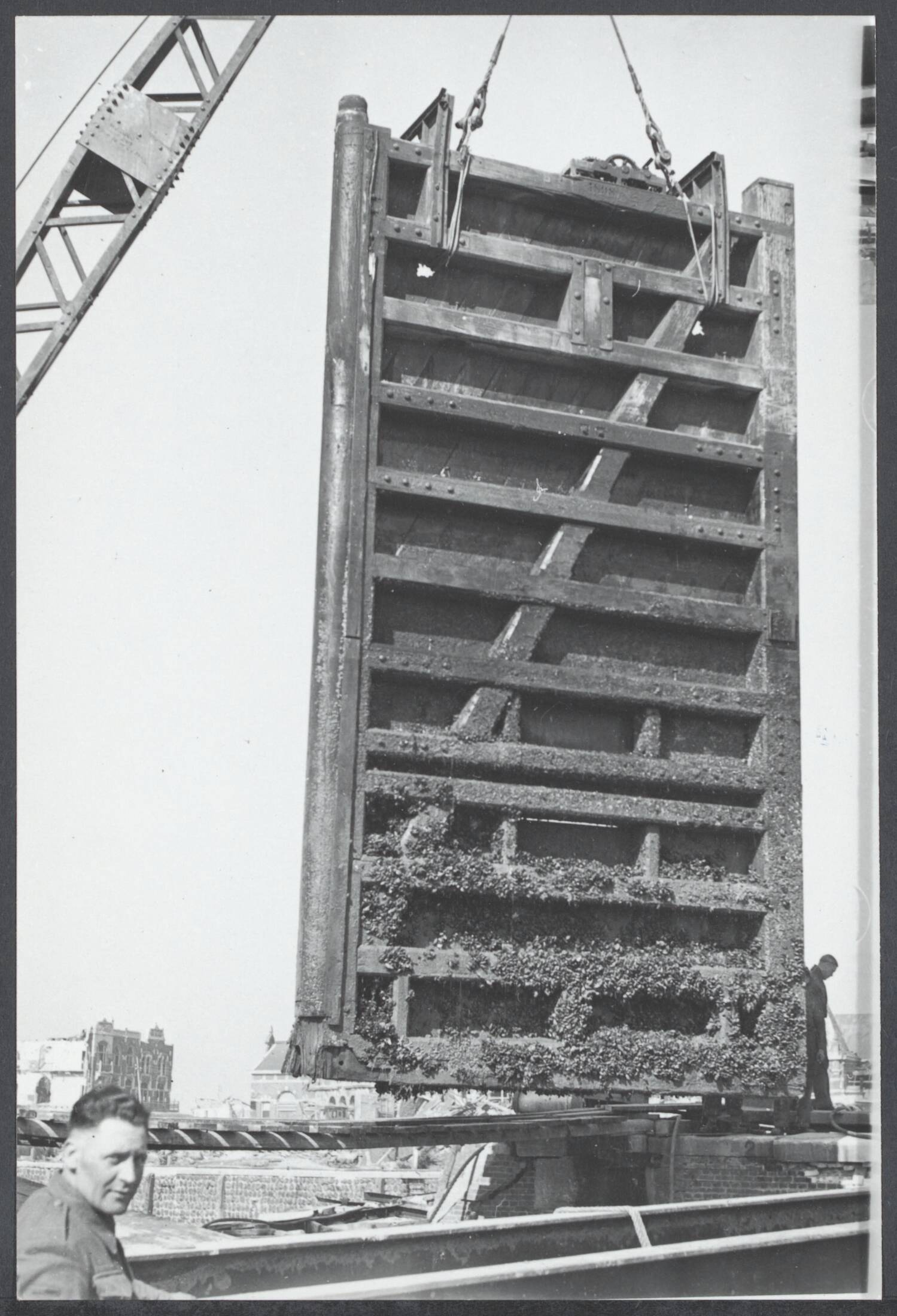 Wederopbouw voorzover niet onder plaats, gebouw. Herstel van 't leven na de oorlog. — Geen bijschrift [Wederopbouw Vlissingen. Herstelwerk aan een haveninstallatie. Optakelen van een sluisdeur] — Foto: Fotograaf Onbekend / Anefo. Licentie: Set B: Rechtenvrij / Publiek Domein. Bron: Nationaal Archief. http://hdl.handle.net/10648/fd3611e7-dd34-1213-6624-85585f4cca04