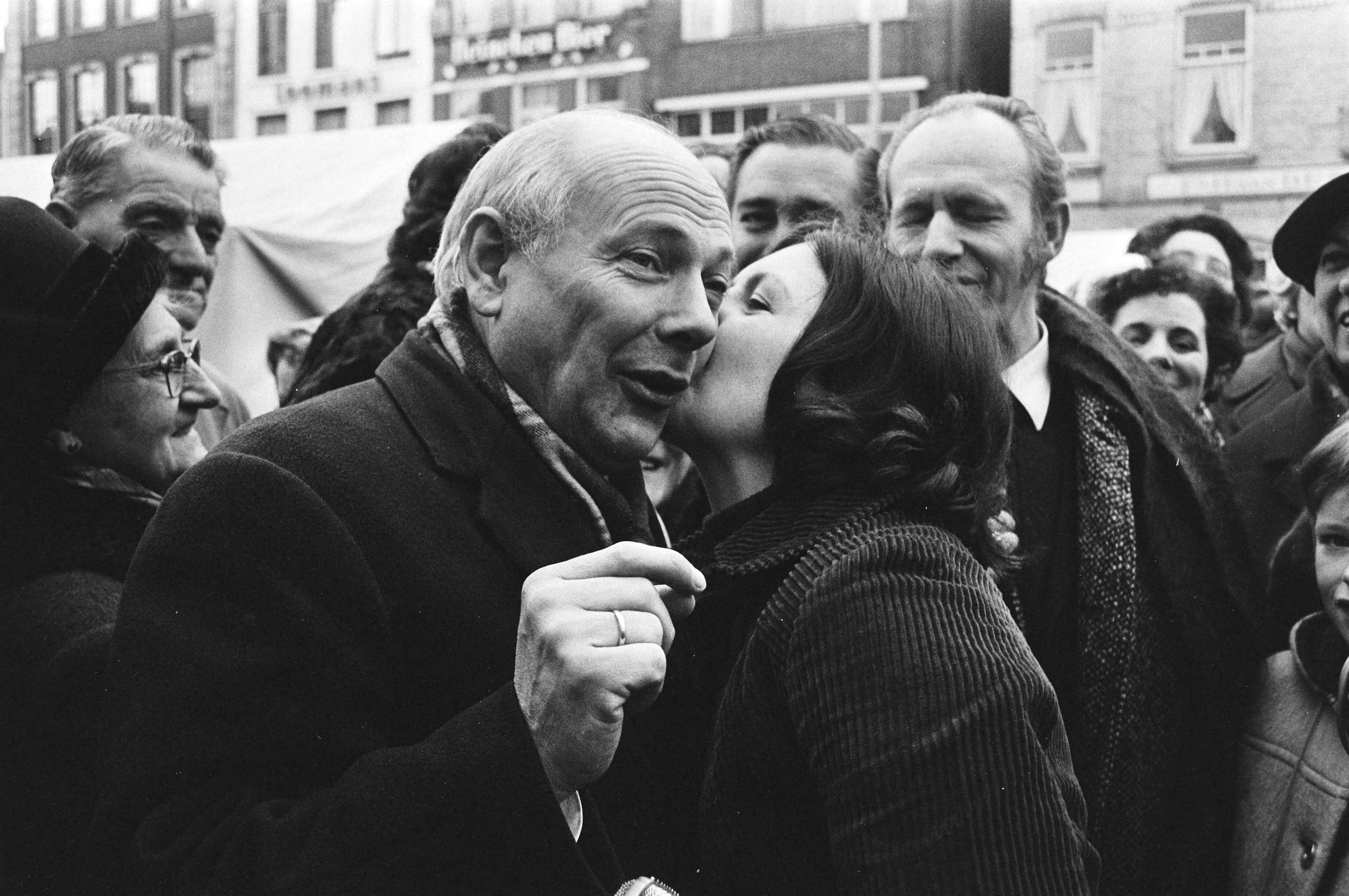 Joop den Uyl in Breda met een karavaan op verkiezingstournee voor de PvdA — Den Uyl krijgt een zoen van een vrouw — Foto: Fotograaf Onbekend / Anefo. Licentie: Set B: Rechtenvrij / Publiek Domein. Bron: Nationaal Archief. http://hdl.handle.net/10648/abb8d7c0-d0b4-102d-bcf8-003048976d84