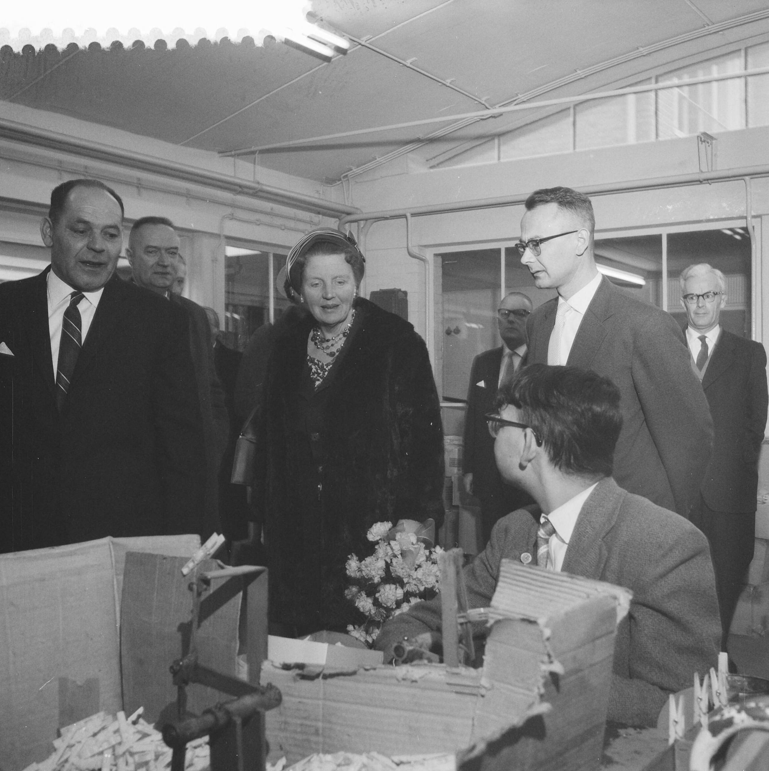 Fotocollectie Anefo — Koningin Juliana bezoekt Ede en Wageningen, bezoek aan de Streekwerkplaats voor minder valide arbeidskrachten te Ede, rondgang door de werkplaats, links van de koningin de directeur van de stichting S. T. Heekelaar — Foto: Pot, Harry / Anefo. Licentie: Set B: Rechtenvrij / Publiek Domein. Bron: Nationaal Archief. http://hdl.handle.net/10648/a9aaa224-d0b4-102d-bcf8-003048976d84