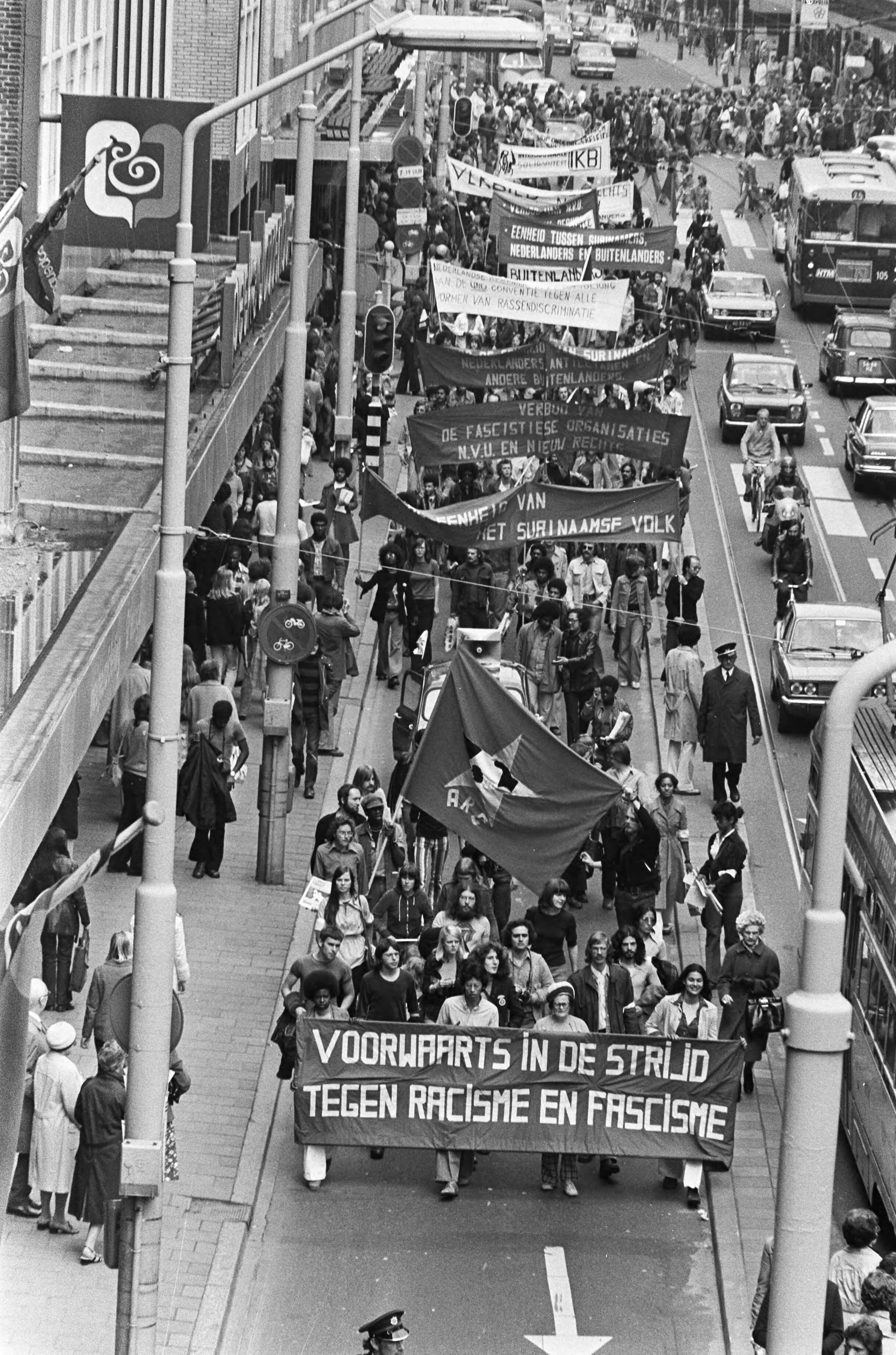 Demonstratie van het Anti-Racisme Comité tegen de Nederlandse Volks-Unie en Nieuw Rechts — Den Haag|Zuid-Holland|demonstraties |spandoeken — Foto: Bogaerts, Rob / Anefo. Licentie: Set B: Rechtenvrij / Publiek Domein. Bron: Nationaal Archief. http://hdl.handle.net/10648/ac68b97e-d0b4-102d-bcf8-003048976d84