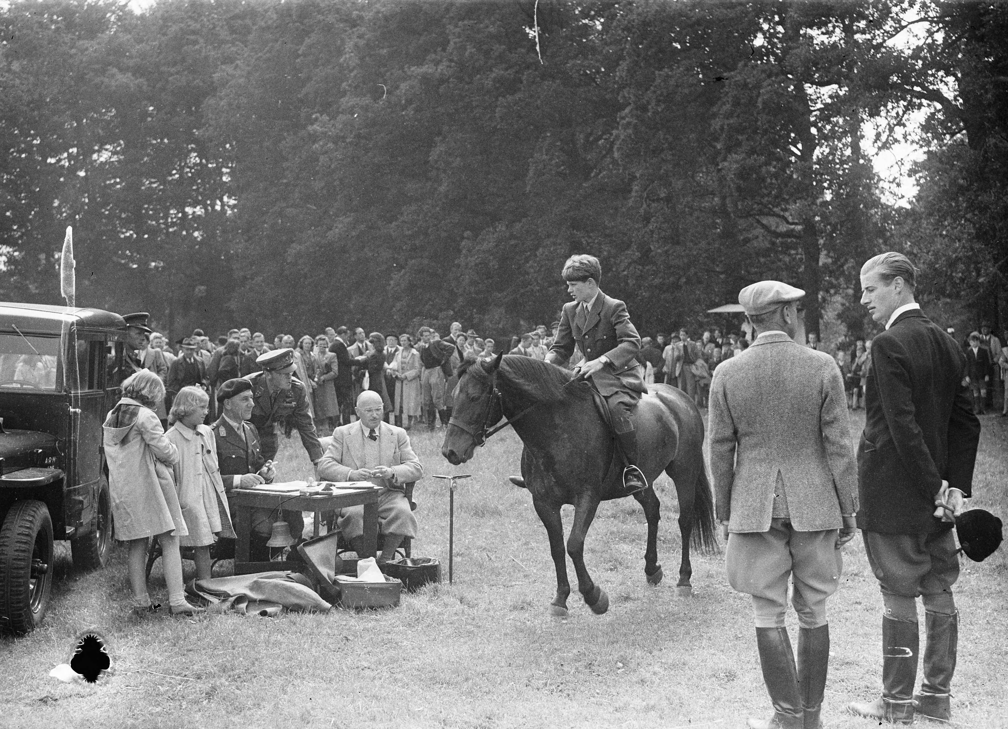 Fotocollectie Anefo — Springconcours te Bussum. De jongste deelnemer stelt zich voor [jonge ruiter op paard bij jurytafel. Bij de jurytafel staan prins Bernhard en zijn dochters Irene en Beatrix] — Foto: Sagers, Harry / Anefo. Licentie: Set B: Rechtenvrij / Publiek Domein. Bron: Nationaal Archief. http://hdl.handle.net/10648/a8a95cda-d0b4-102d-bcf8-003048976d84