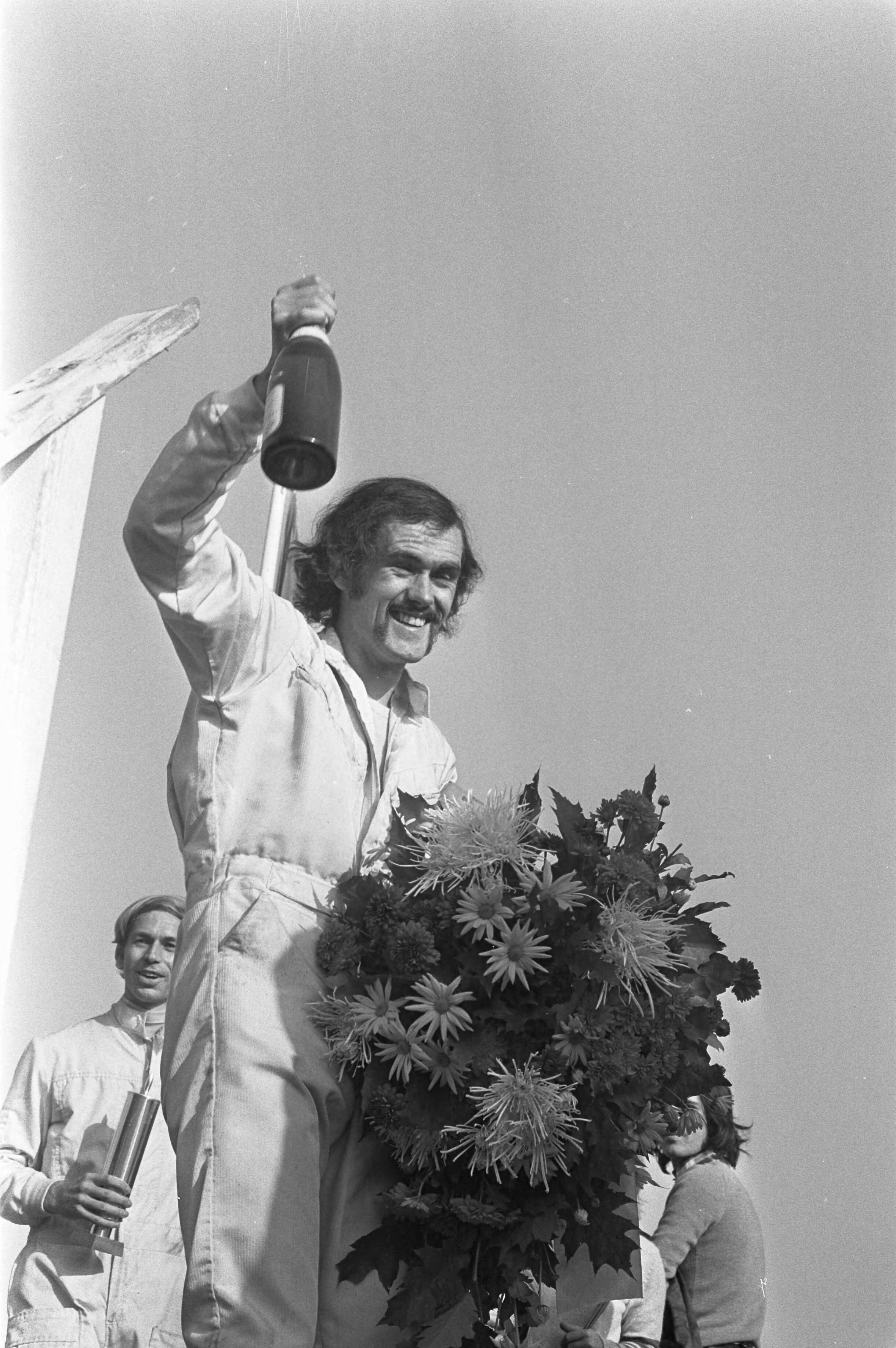 Fotocollectie Anefo — Slotraces op Zandvoort (auto), Jelle Hingst , Nederlands kampioen Formule Vee , met champagne en bloemen — Foto: Croes, Rob C. / Anefo. Licentie: Set B: Rechtenvrij / Publiek Domein. Bron: Nationaal Archief. http://hdl.handle.net/10648/abf8a7a6-d0b4-102d-bcf8-003048976d84