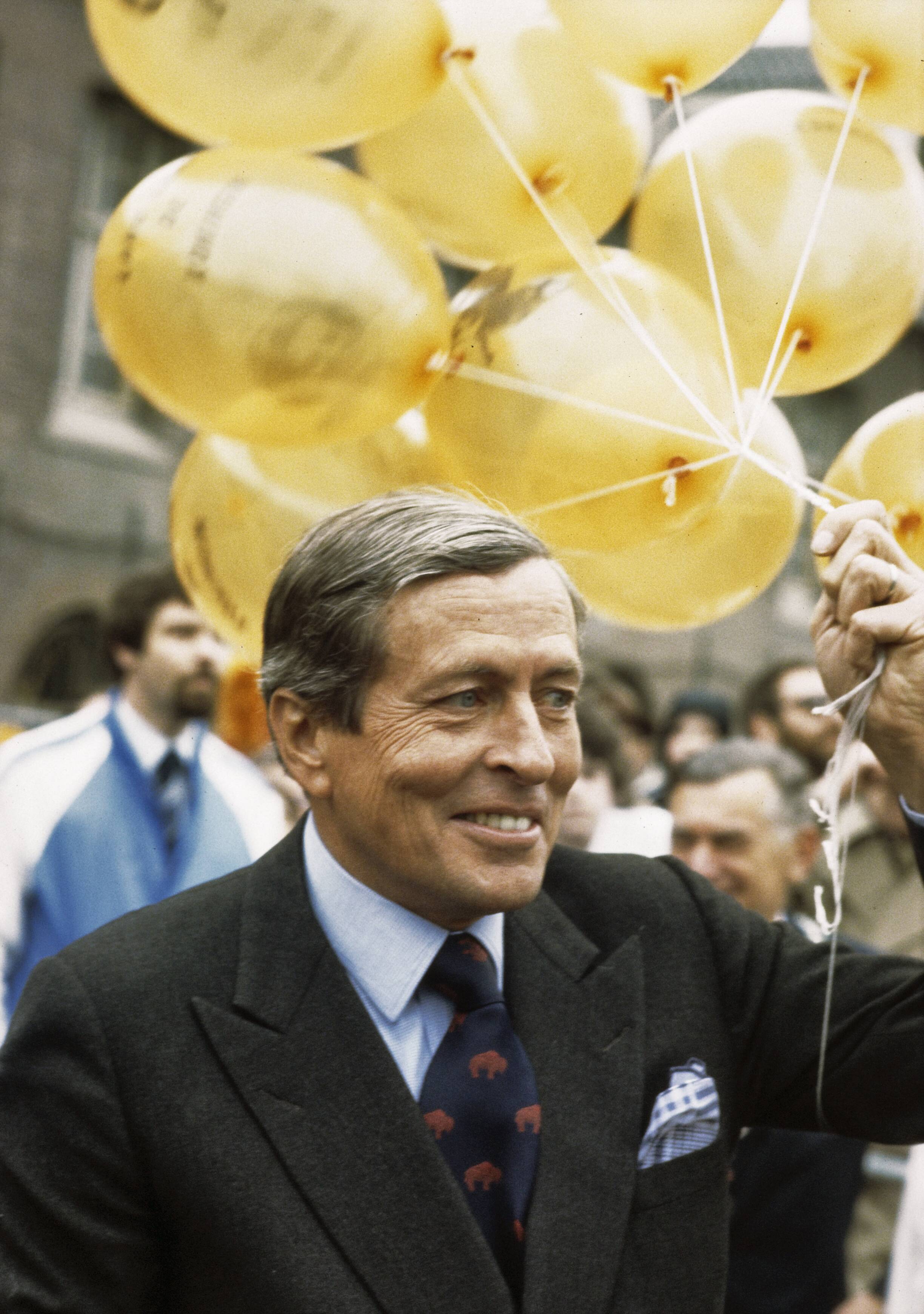 Fotocollectie Anefo — Viering Koninginnedag in Breda; Prins Claus met gele ballonnen — Foto: Bogaerts, Rob / Anefo. Licentie: Set B: Rechtenvrij / Publiek Domein. Bron: Nationaal Archief. http://hdl.handle.net/10648/ad8a8710-d0b4-102d-bcf8-003048976d84