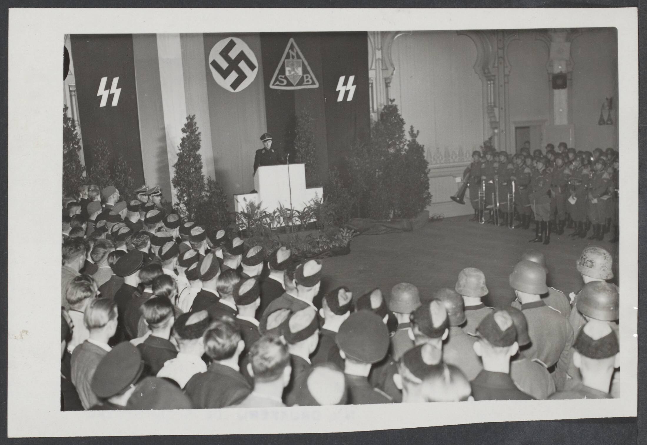 Vrijwilligers Legioen Nederland — Vertrek van enige honderden Nederlandse vrijwilligers naar het Oostfront. Toespraak van de plaatsvervangend leider van de NSB, C. van Geelkerken, in de Dierentuin te Den Haag — Foto: Meijer, T.A. / Centraal Nederlandsch Fotopersbureau [CNF]. Licentie: Set B: Rechtenvrij / Publiek Domein. Bron: Nationaal Archief. http://hdl.handle.net/10648/7f274272-afad-6e67-a4f4-d348da4c05d4