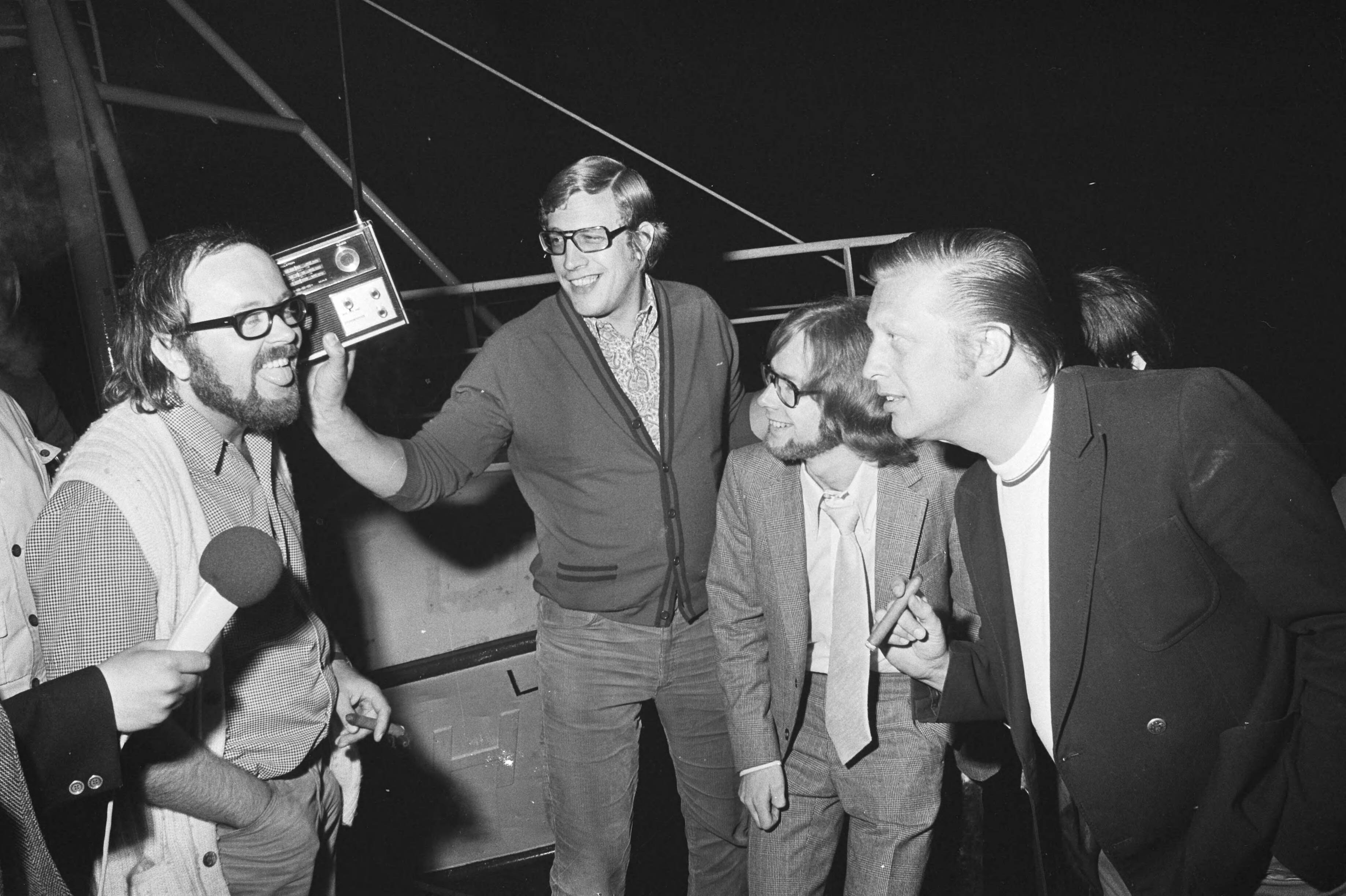 Fotocollectie Anefo — Diskjockeys van Radio Noordzee in de haven van Scheveningen, v.l.n.r. Joost den Draaijer, Jan van Veen en Ferry Maat — Foto: Verhoeff, Bert / Anefo. Licentie: Set B: Rechtenvrij / Publiek Domein. Bron: Nationaal Archief. http://hdl.handle.net/10648/abbf7efe-d0b4-102d-bcf8-003048976d84