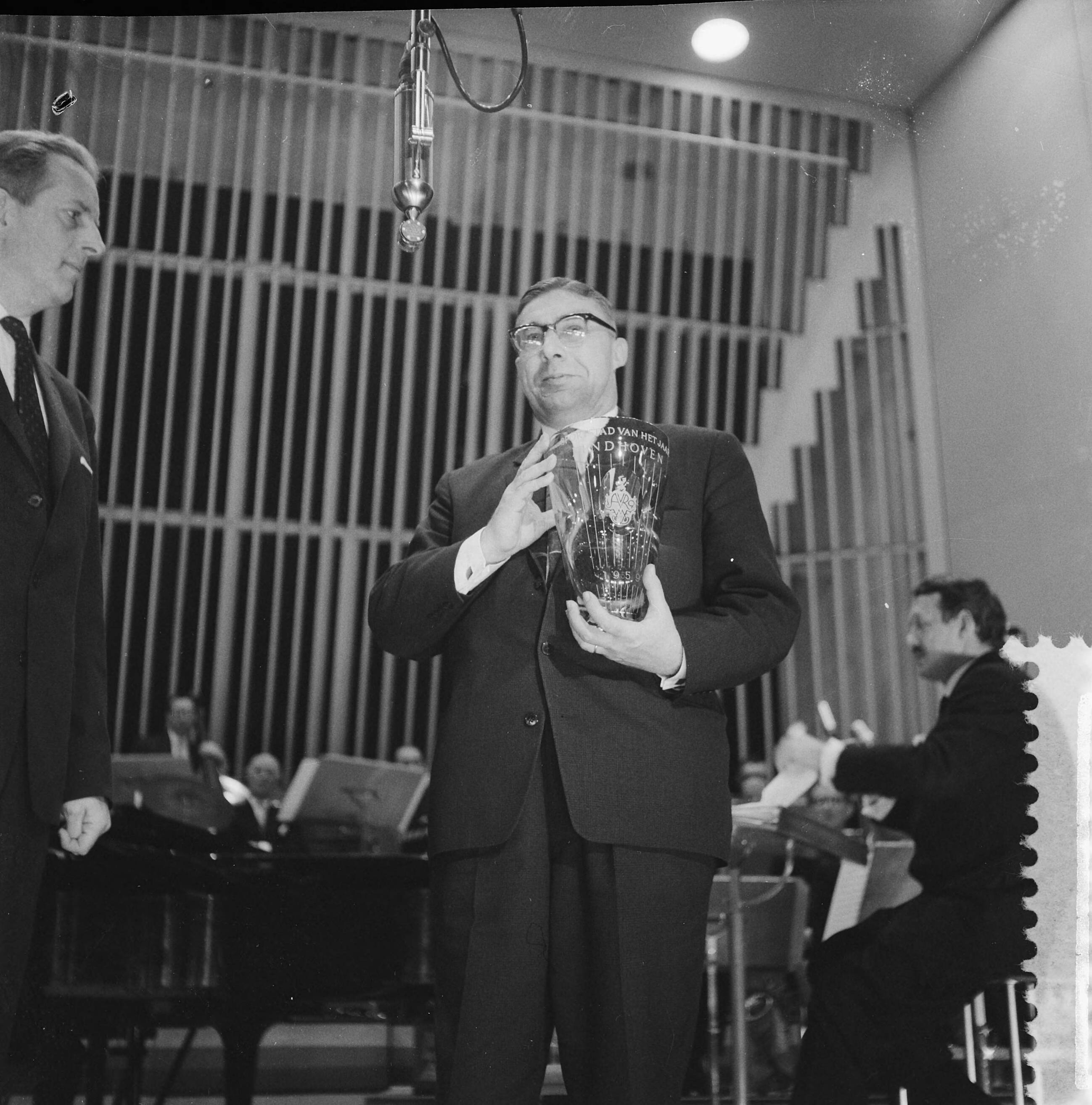 Fotocollectie Anefo — Verkiezing Sportman, Sportvrouw en Sportstad van het jaar. Directeur van de AVRO, D. Repko, overhandigt de loco-burgemeester van Eindhoven F.J.W. Gijzels de bokaal — Foto: Lindeboom, Henk / Anefo. Licentie: Set B: Rechtenvrij / Publiek Domein. Bron: Nationaal Archief. http://hdl.handle.net/10648/a9a4dcf4-d0b4-102d-bcf8-003048976d84