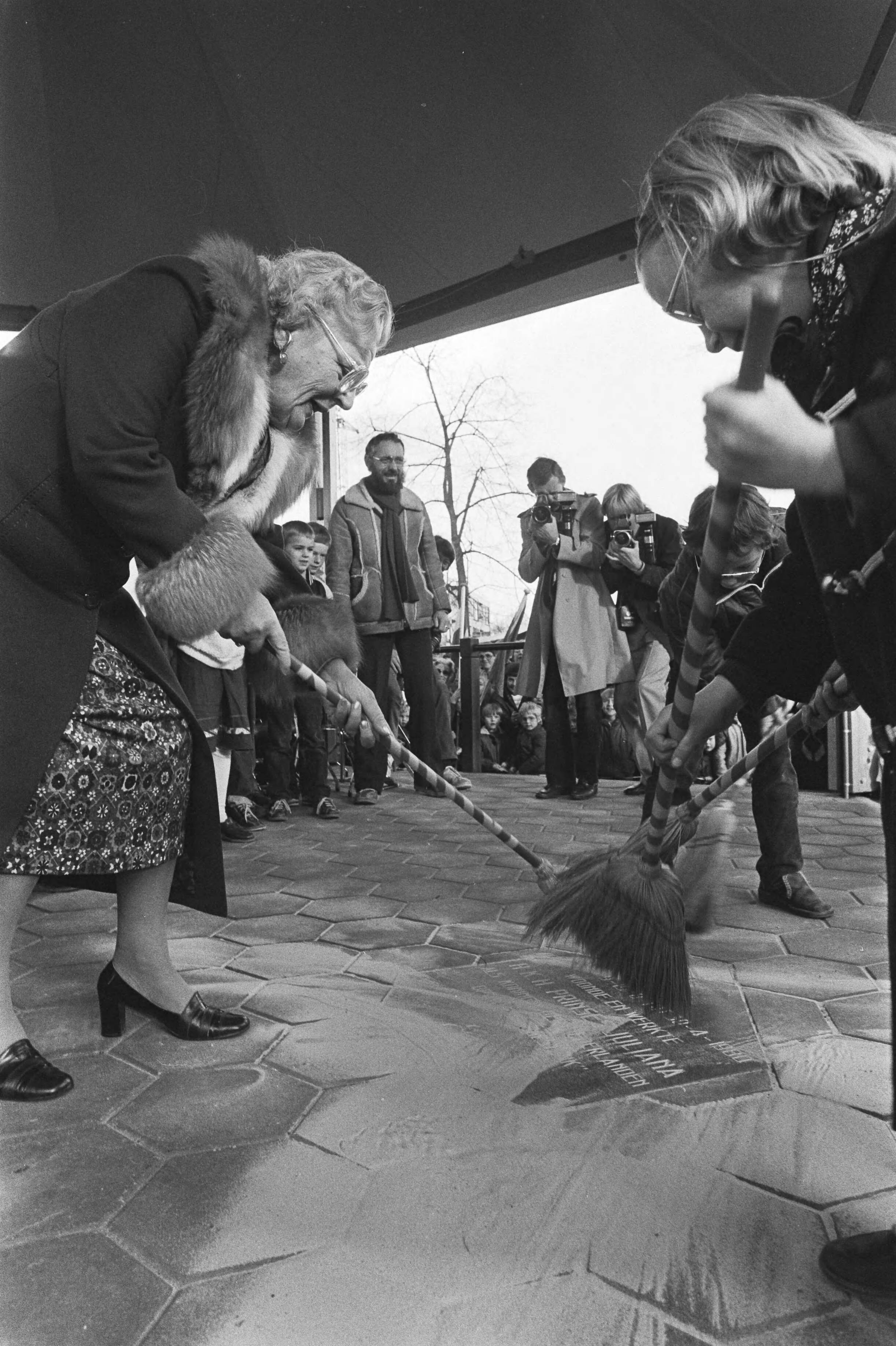 Prinses Juliana heeft in Baarn de muziektent op de Brink officiëel in gebruik — Prinses Juliana veegt, samen met enkele kinderen, zand van de herinneringstegel — Foto: Dijk, Hans van / Anefo. Licentie: Set B: Rechtenvrij / Publiek Domein. Bron: Nationaal Archief. http://hdl.handle.net/10648/ad085cb8-d0b4-102d-bcf8-003048976d84