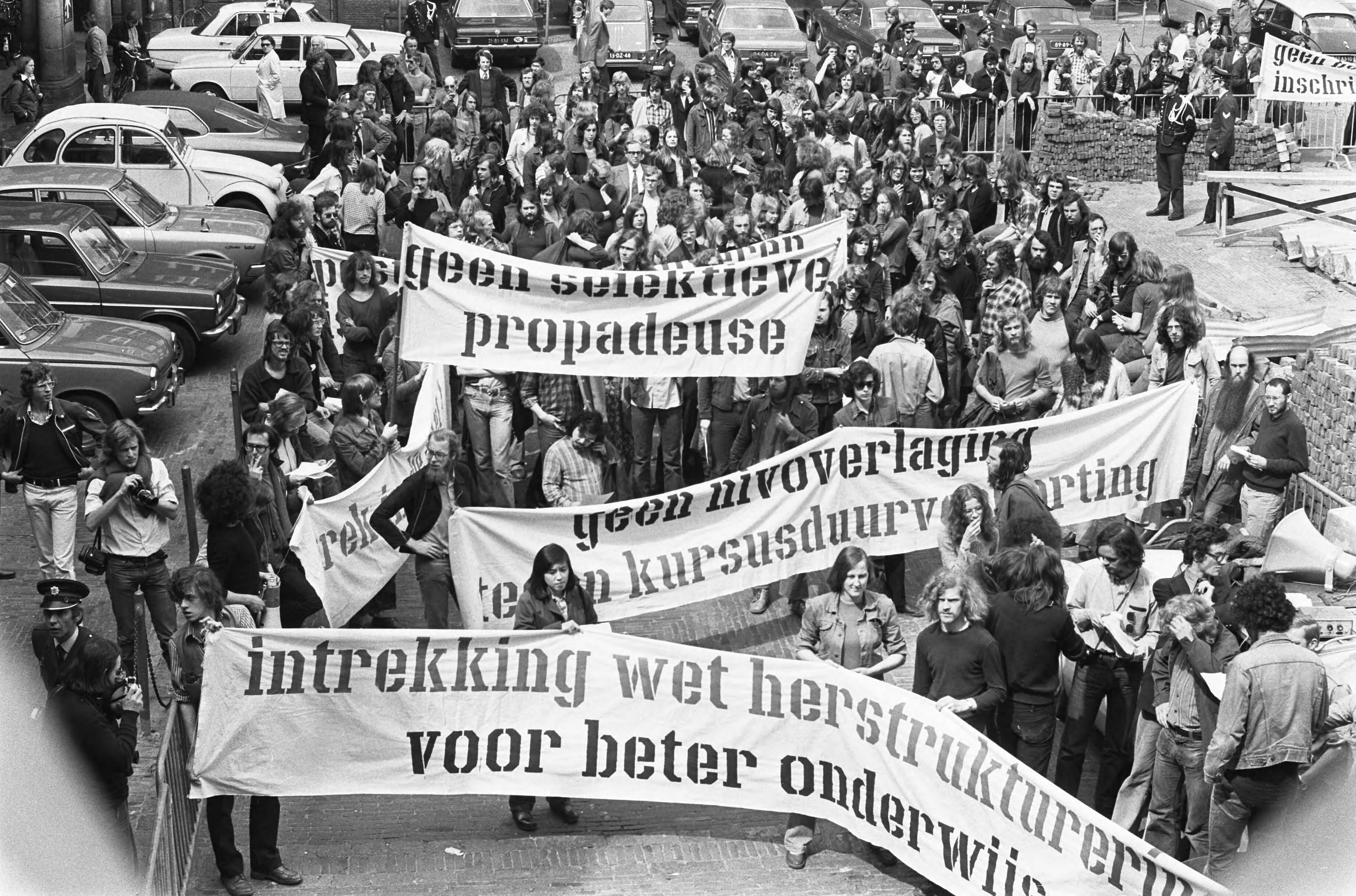 Studenten demonstreren op het Binnenhof voor intrekking van de Wet herstructurering wetenschappelijk onderwijs — Den Haag|Zuid-Holland|studenten |demonstraties |spandoeken |reorganisaties |onderwijs — Foto: Peters, Hans / Anefo. Licentie: Set B: Rechtenvrij / Publiek Domein. Bron: Nationaal Archief. http://hdl.handle.net/10648/ac6765f6-d0b4-102d-bcf8-003048976d84