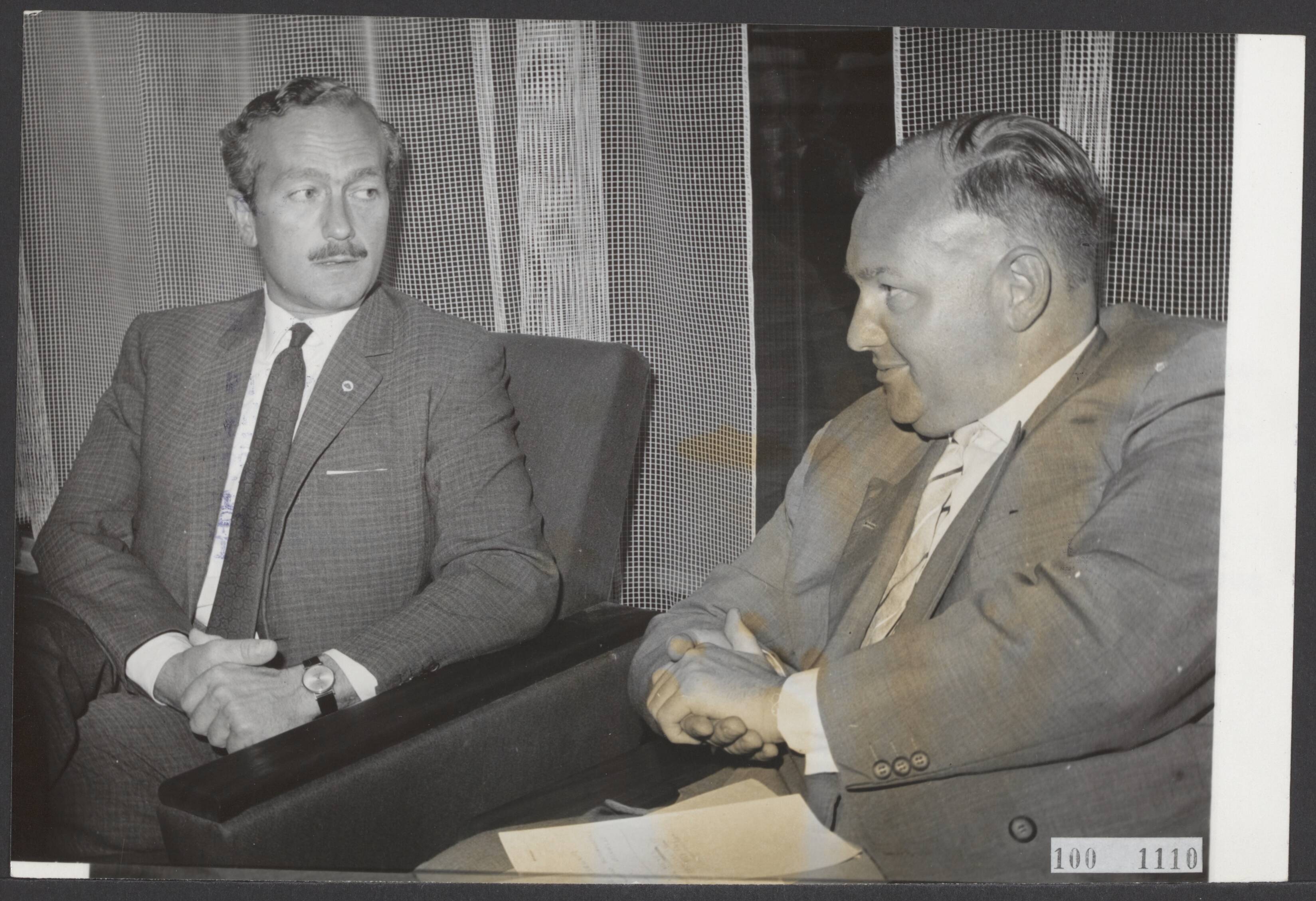 Fotocollectie Elsevier Binnenland — Colin Chapman, de manager van [autocoureur] Jim Clark, die door de Zandvoortse politie was gearresteerd, is door de Officier van Justitie te Haarlem vrijgelaten, op voorwaarde dat hij op 20 juli zal verschijnen voor de politierechter. Na zijn vrijlating ging Chapman (links) naar het Bouwes Palace Hotel te Zandvoort waar hij enige persvertegenwoordigers te woord stond. Naast hem zijn advocaat mr. A.S. Groen — Foto: Evers, Joost / Anefo. Licentie: Set B: Rechtenvrij / Publiek Domein. Bron: Nationaal Archief. http://hdl.handle.net/10648/ae2e2488-d0b4-102d-bcf8-003048976d84