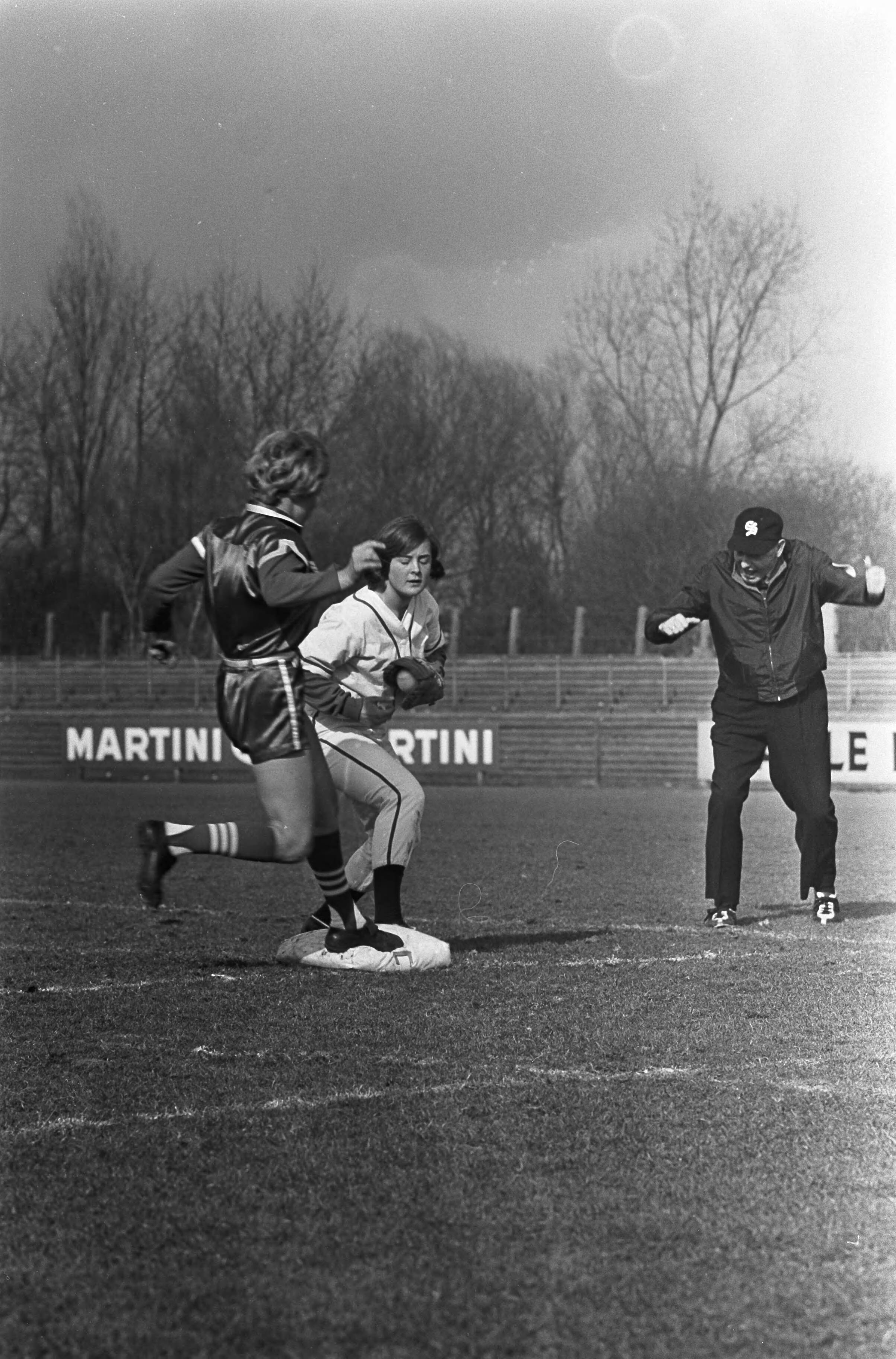 Fotocollectie Anefo — Dames softbal. Nederland tegen de Raybestos Brakkettes (Amerikaanse dames) 0-11. Spelmoment, de Nederlandse Ludi Handgraaf zorgt dat de Amerikaanse loopster uit is — Foto: Kroon, Ron / Anefo. Licentie: Set B: Rechtenvrij / Publiek Domein. Bron: Nationaal Archief. http://hdl.handle.net/10648/aa990446-d0b4-102d-bcf8-003048976d84