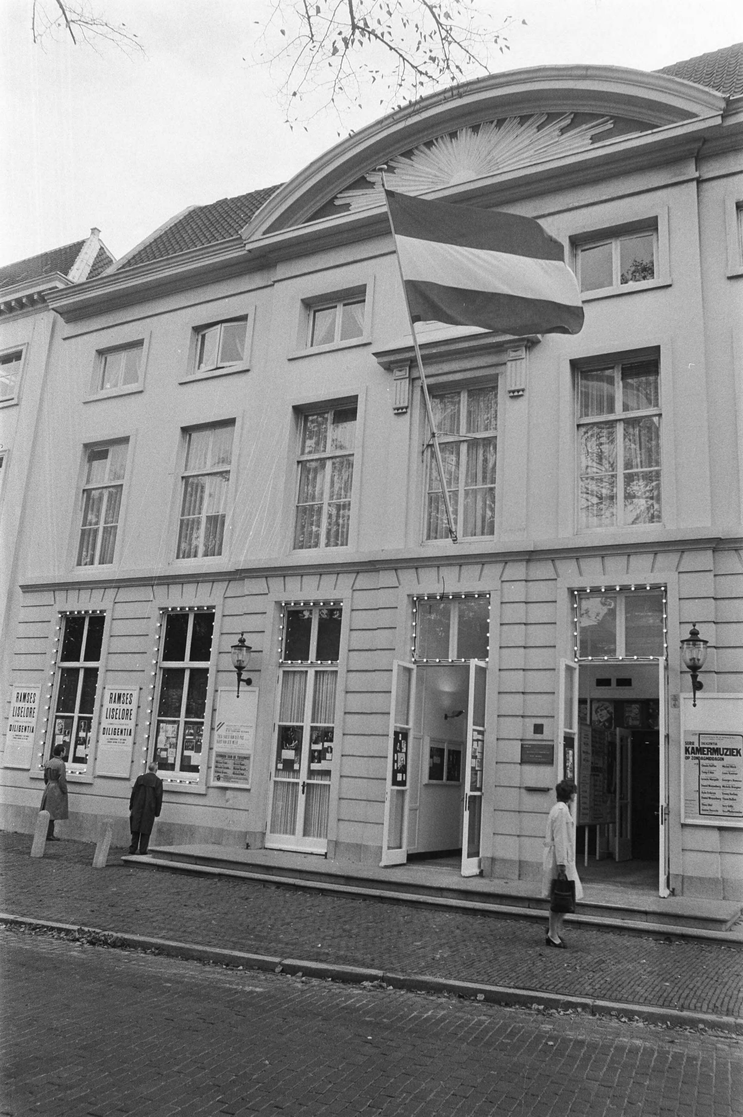 Fotocollectie Anefo — Theater Diligentia heropend, Den Haag , exterieur met vlag — Foto: Verhoeff, Bert / Anefo. Licentie: Set B: Rechtenvrij / Publiek Domein. Bron: Nationaal Archief. http://hdl.handle.net/10648/abd19aee-d0b4-102d-bcf8-003048976d84