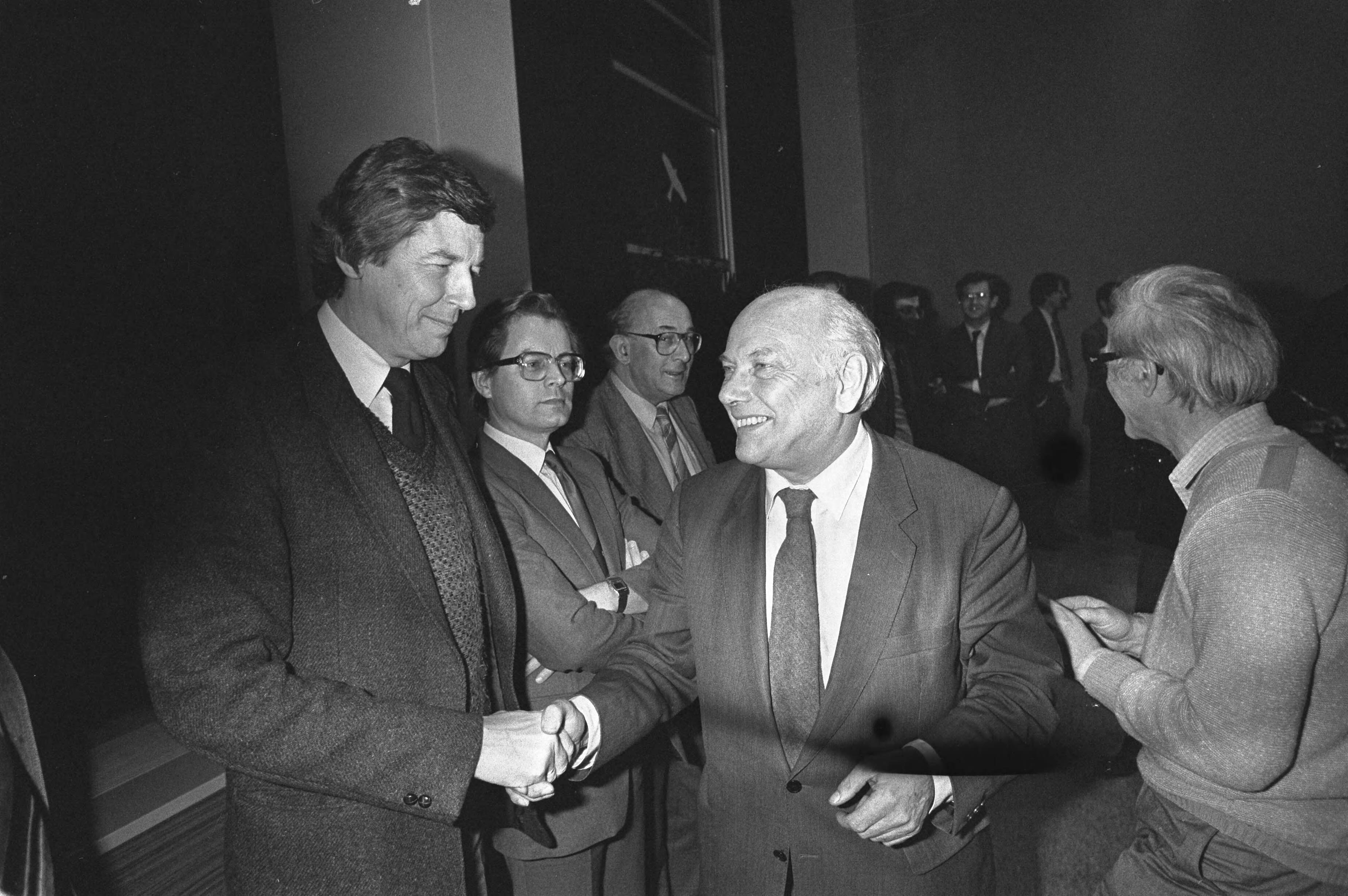 Centraal overleg tussen regering, werkgevers en werknemers in het SER-gebouw in Den Haag — Den Uyl (PvdA, rechts) begroet Wim Kok (voorzitter FNV) — Foto: Croes, Rob C. / Anefo. Licentie: Set B: Rechtenvrij / Publiek Domein. Bron: Nationaal Archief. http://hdl.handle.net/10648/ad0a4ece-d0b4-102d-bcf8-003048976d84