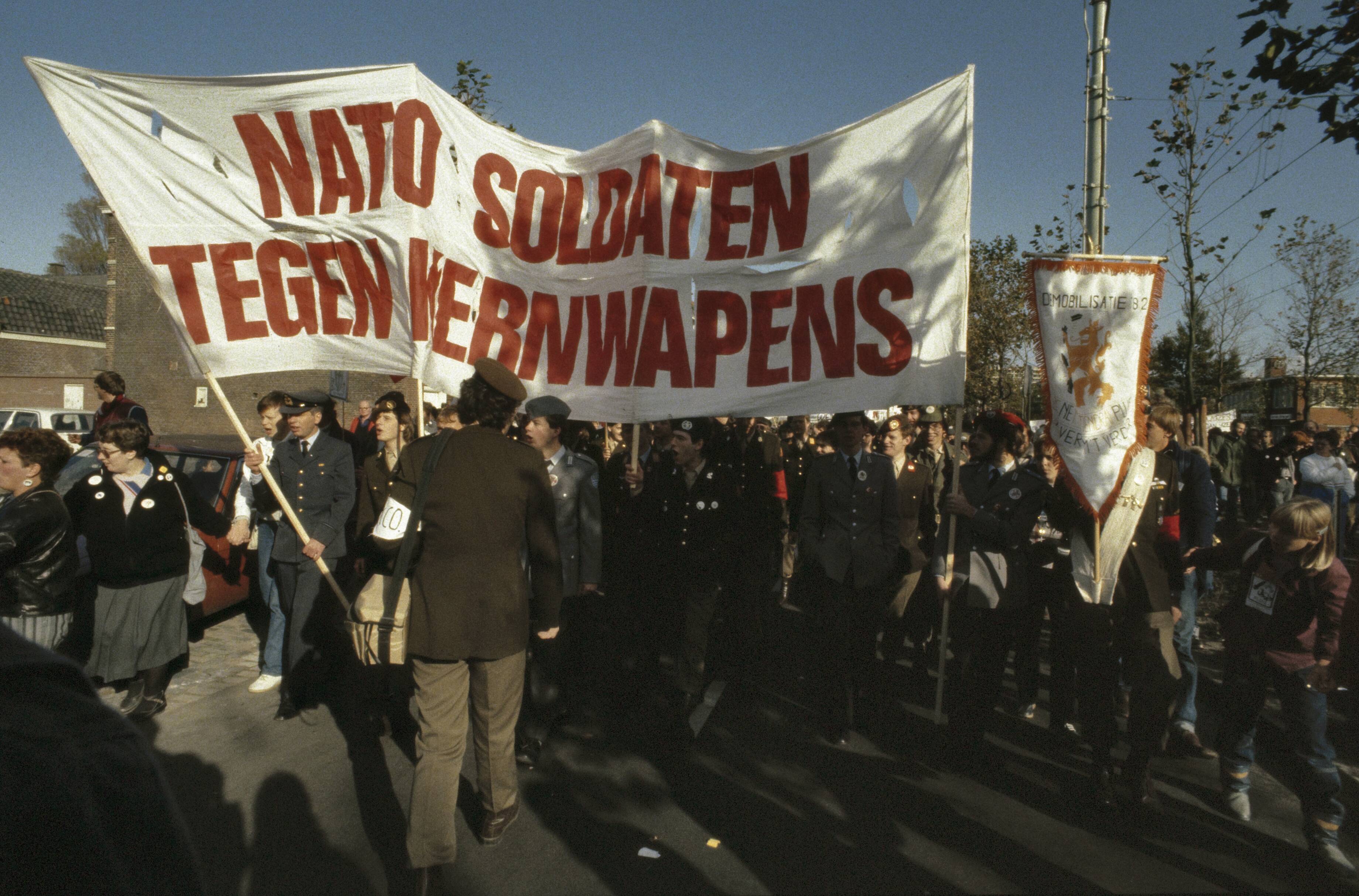 Fotocollectie Anefo — Anti kernwapendemonstratie in Den Haag ( 550 duizend deelnemers ); NATO soldaten tegen kernwapens — Foto: Antonisse, Marcel / Anefo. Licentie: Set B: Rechtenvrij / Publiek Domein. Bron: Nationaal Archief. http://hdl.handle.net/10648/ad8b6694-d0b4-102d-bcf8-003048976d84