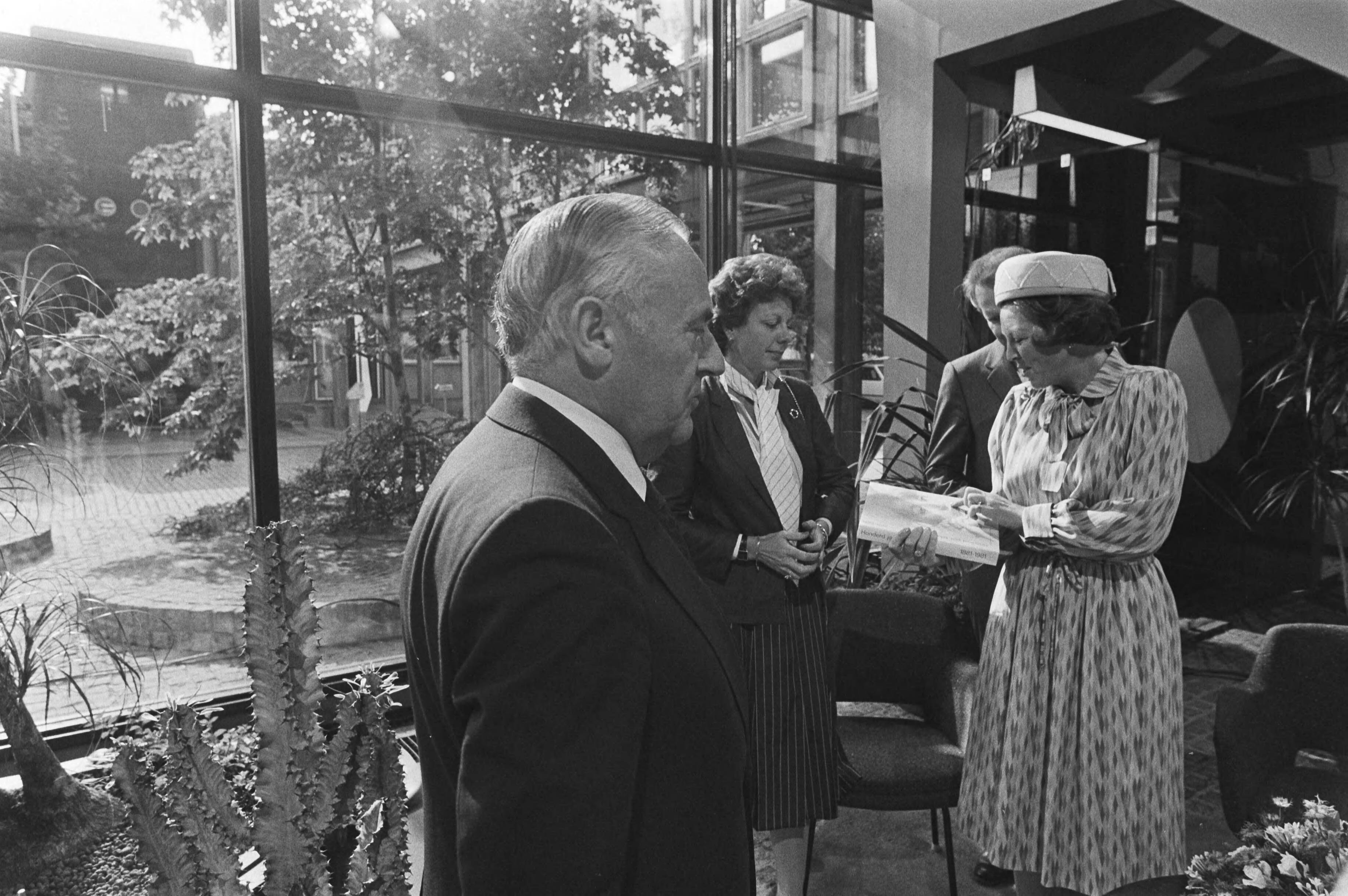 Bezoek van Koningin Beatrix aan de PTT in verband met het 100-jarig bestaan — Koningin Beatrix ontvangt in het Dr. Neherlaboratorium te Leidschendam (het ontwikkelingslaboratorium van de PTT) het jubileumboek "Honderd jaar telefonie" van v.l.n.r. de heer Ph. Leenman (directeur-generaal van de PTT), mevrouw Smit-Kroes (staatssecretaris van verkeer en waterstaat) en ir. A. Boesvelt (directeur dr. Neherlaboratorium) — Foto: Dijk, Hans van / Anefo. Licentie: Set B: Rechtenvrij / Publiek Domein. Bron: Nationaal Archief. http://hdl.handle.net/10648/ad02a106-d0b4-102d-bcf8-003048976d84