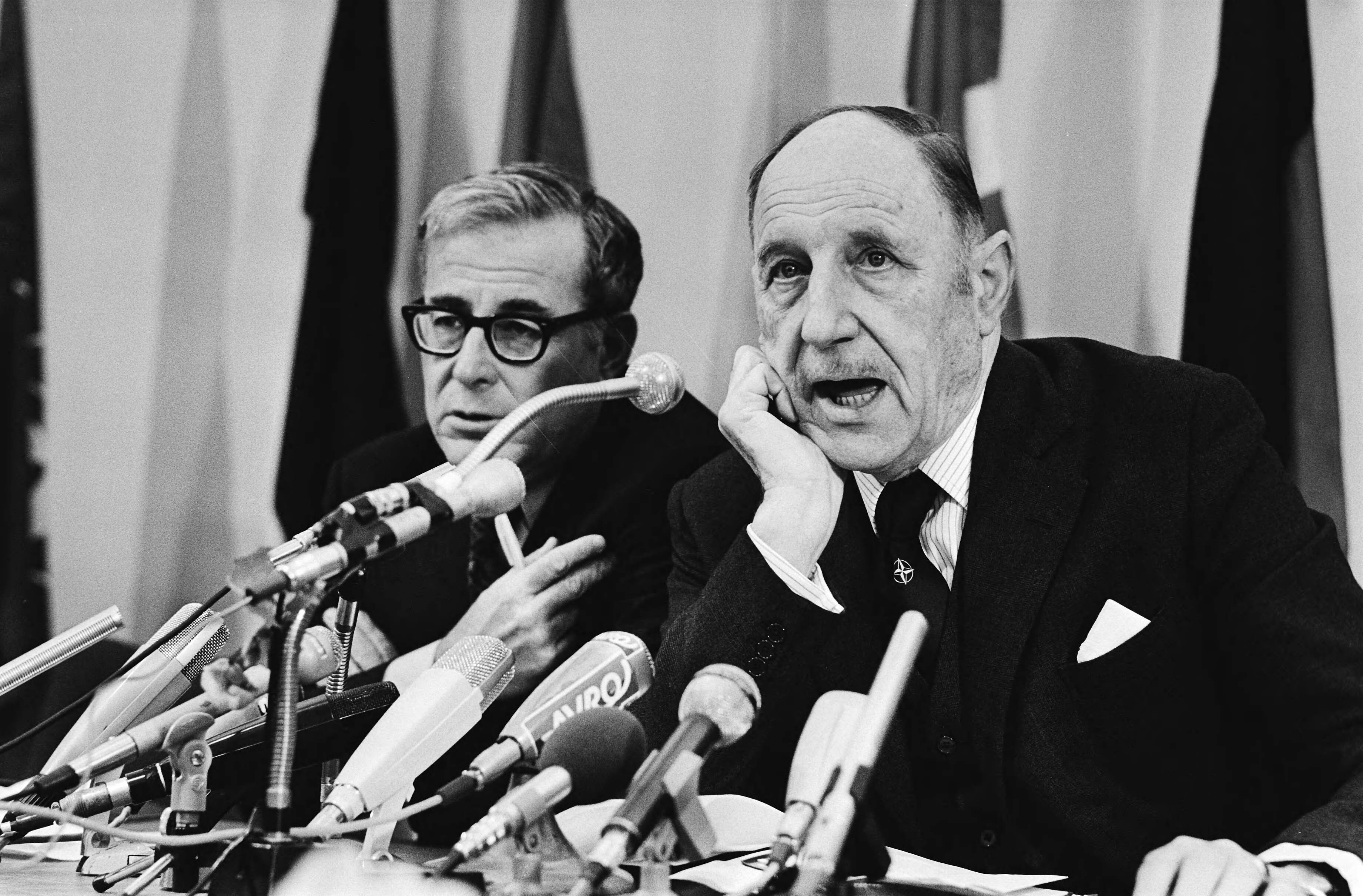 Persconferentie na NATO overleg in Den Haag van NATO — Harold Brown (l) en Joseph Luns — Foto: Croes, Rob C. / Anefo. Licentie: Set B: Rechtenvrij / Publiek Domein. Bron: Nationaal Archief. http://hdl.handle.net/10648/acd4c2c2-d0b4-102d-bcf8-003048976d84